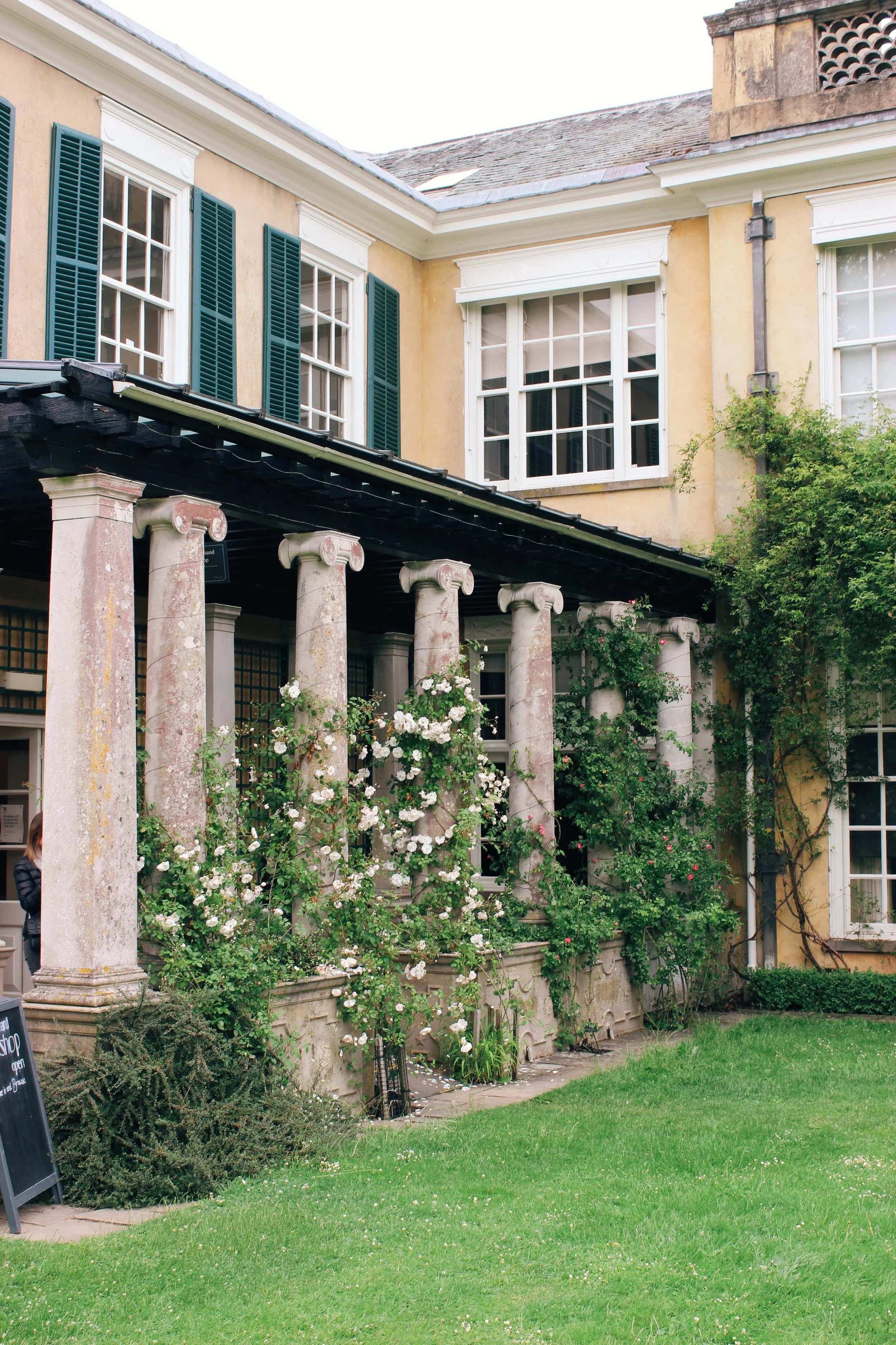 Polesden Lacey porch with colonnade climbing white roses