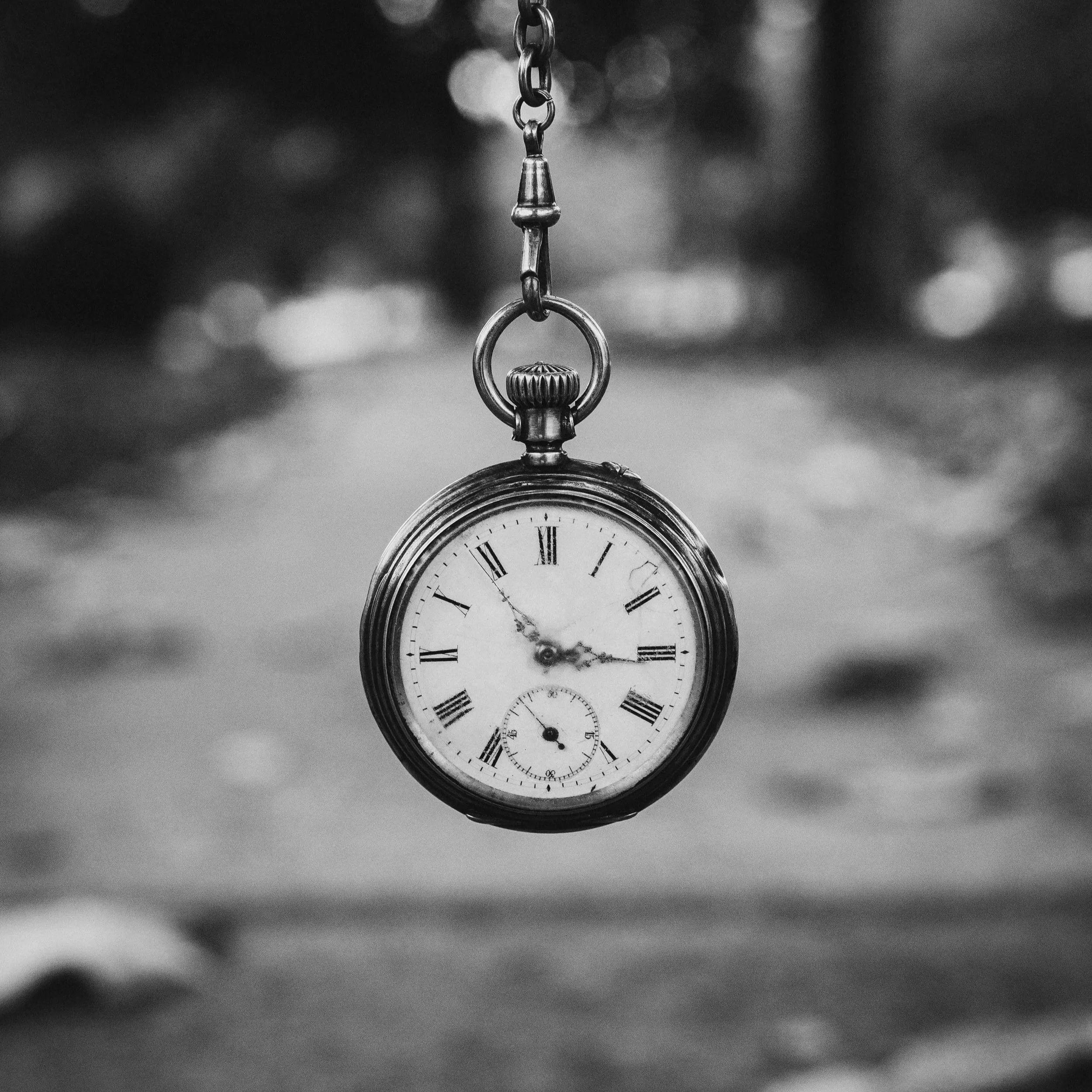 Silhouettes of two people on a boat at sunset, with a dramatic orange and purple sky reflected on calm water.