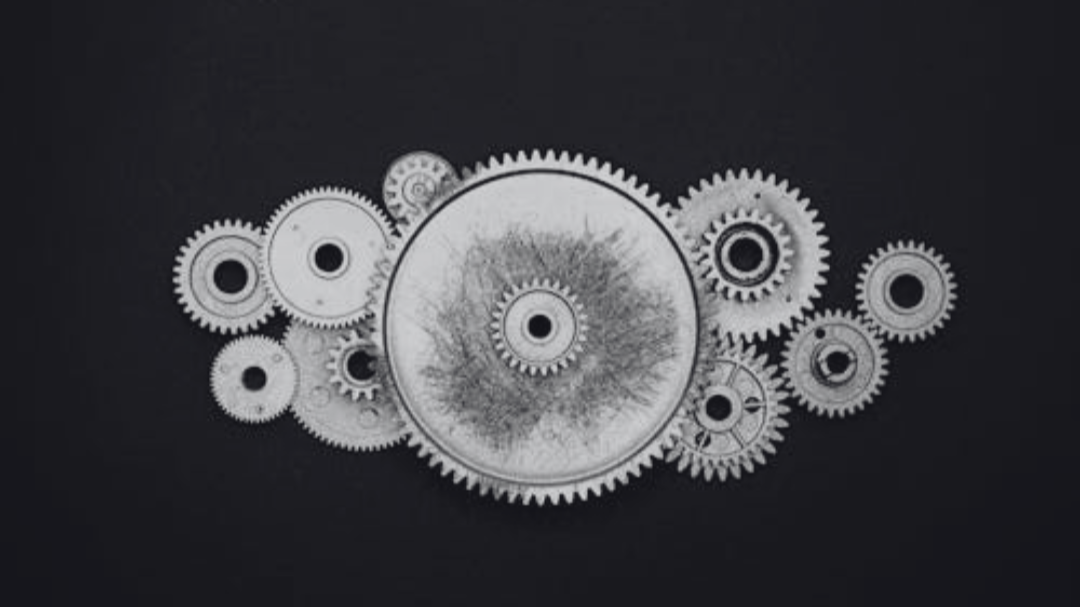 Arrangement of silver gears and cogs on a black background.