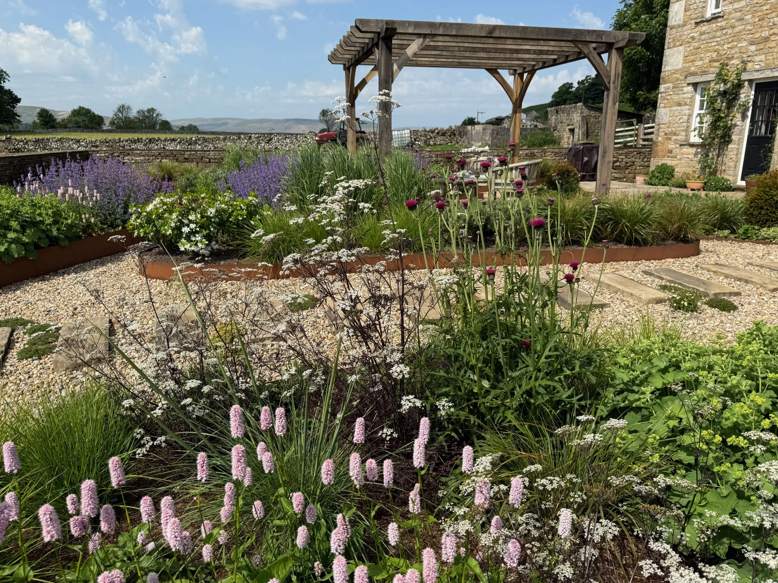 Oak pergola surrounded by perennials and Corten raised beds