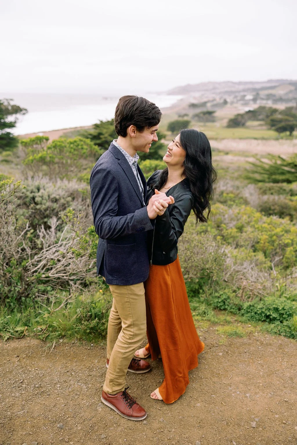  man and woman hugging on the trails at their engagement session in Mori Pt, Pacifica 