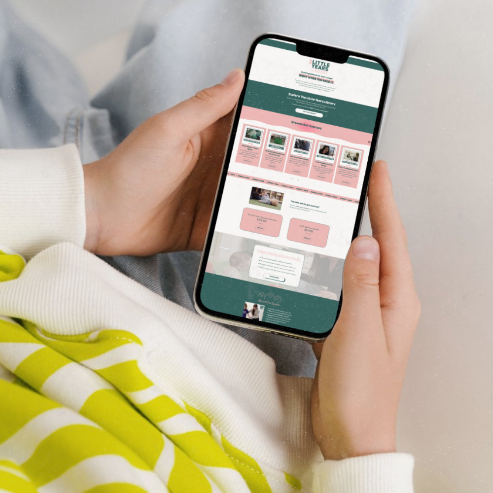 Person holding a smartphone displaying a website or app related to a library or course browsing platform, with a colorful interface featuring course options and subscription details.