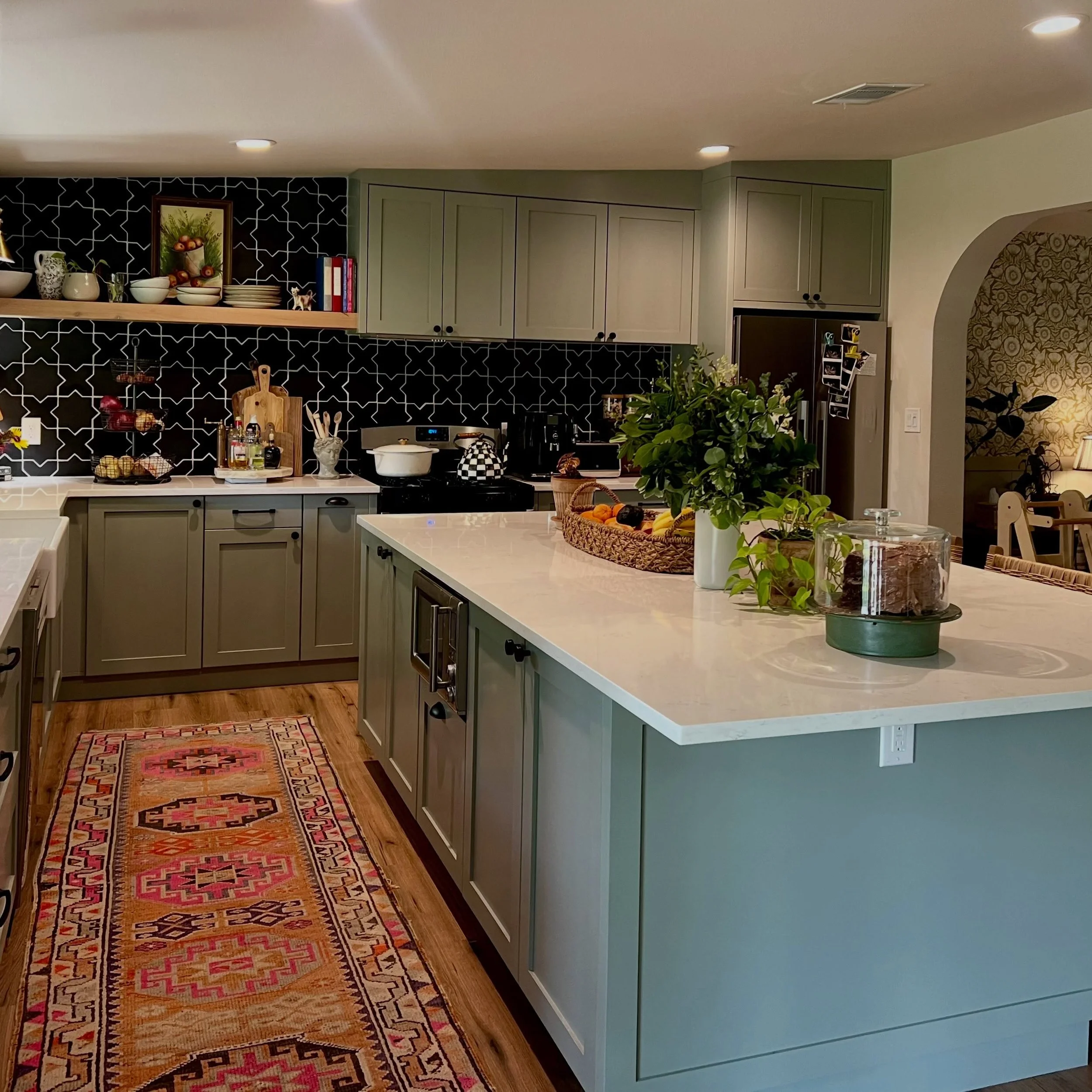 Beautifully crafted cabinetry sets the foundation for a kitchen full of character, with a soft painted finish and tailored details that feel both classic and completely personal. Paired with a bold geometric backsplash, warm wood tones, and collected