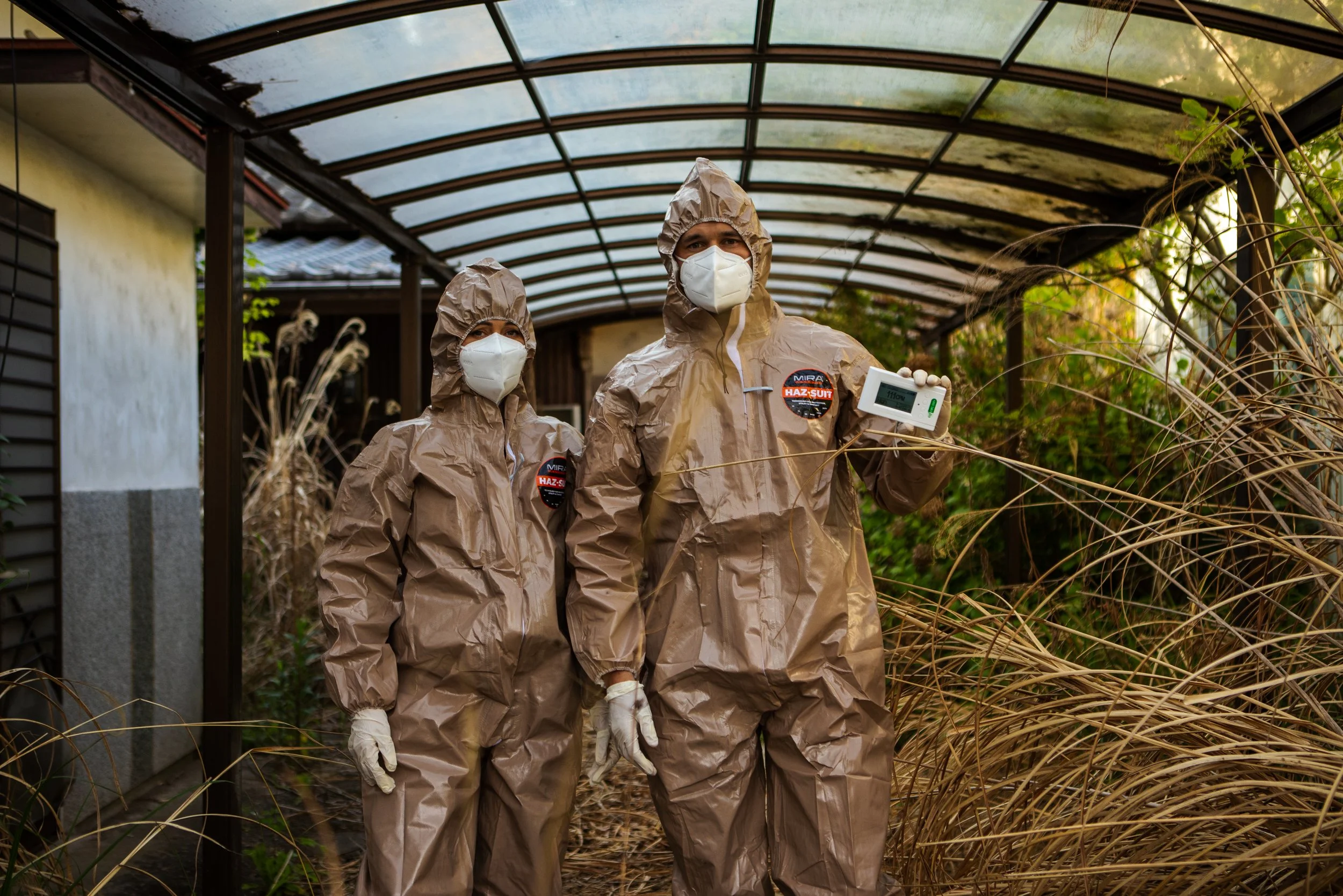 Phil and Jess pose with a Geiger counter in Fukushima. The staccato clicking sounds pierced through every thought like a rake across concrete. 