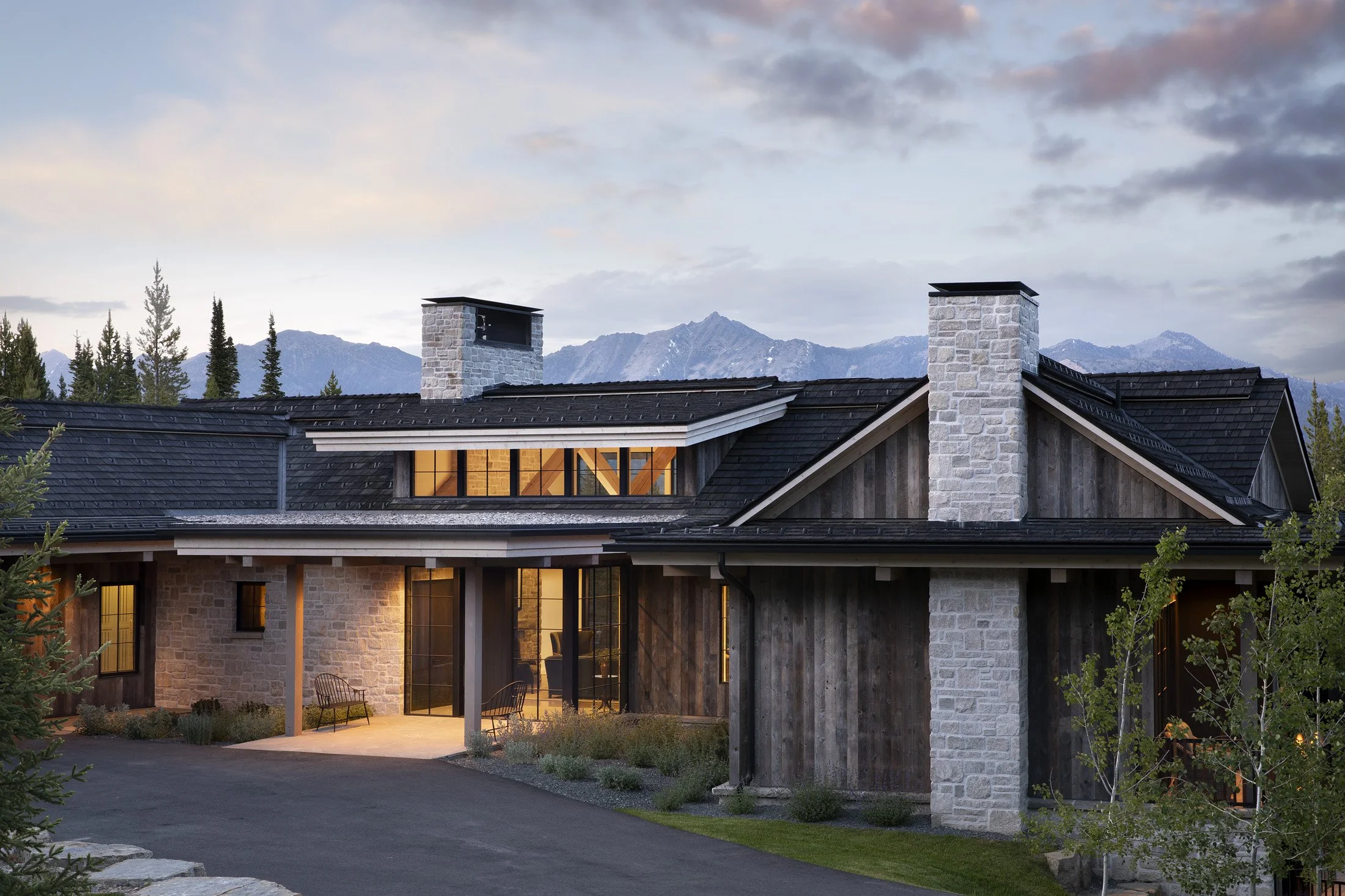 Rustic modern luxury new construction ski home in Big Sky, Montana with gray stone and shoshugibon exterior and unbelievable view of surrounding mountain range, interior design by Hive Home
