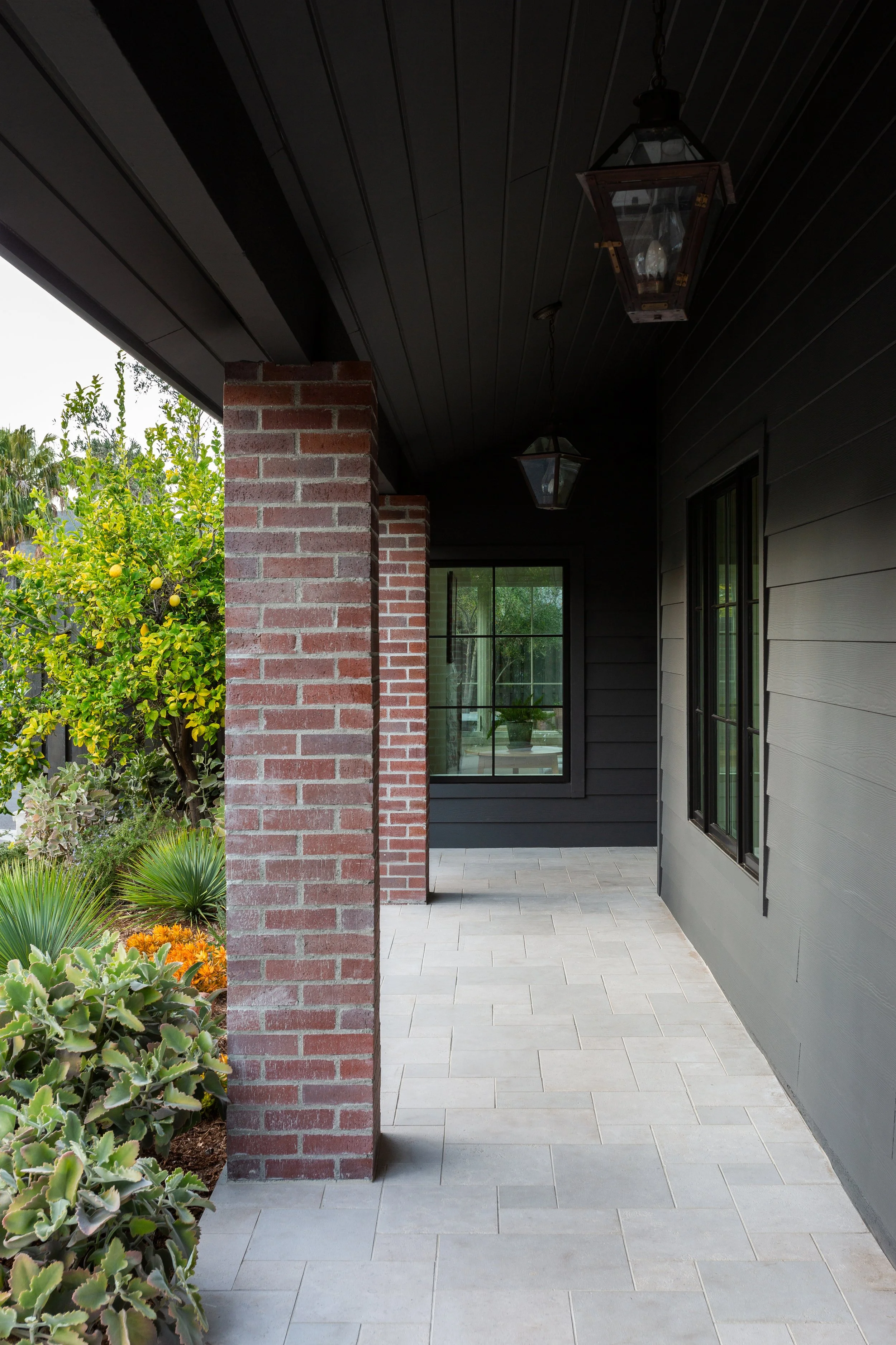 Avenida Pacific Palisades Transitional Black Exterior with Stone Pavers and Brick elements, black windows designed by Hive Home