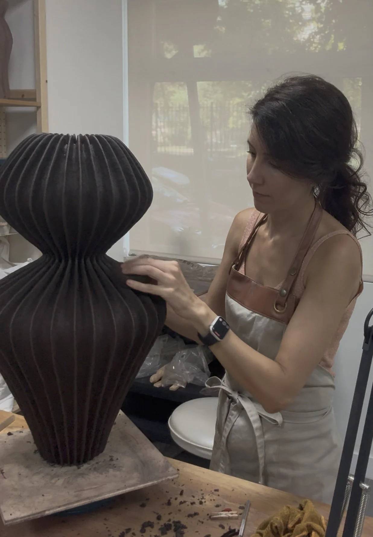 Laura Ramirez refining a large ceramic sculpture in her Madrid studio.