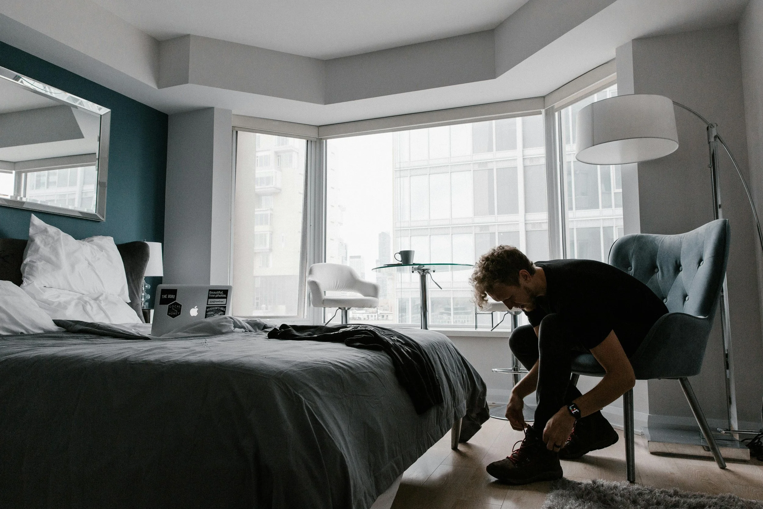 Man tying his shoes in a modern bedroom.