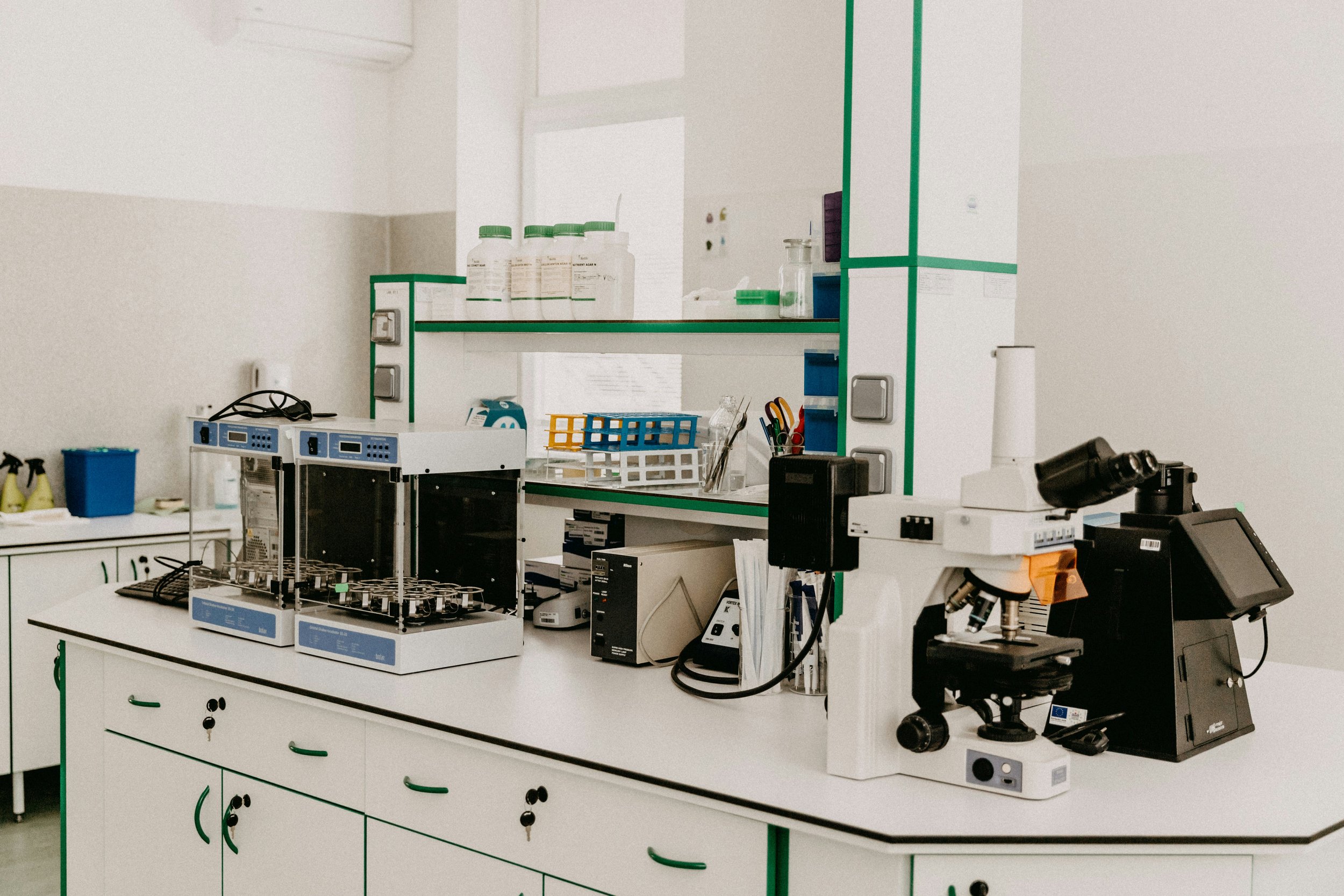 A clean modern laboratory with a technician testing samples
