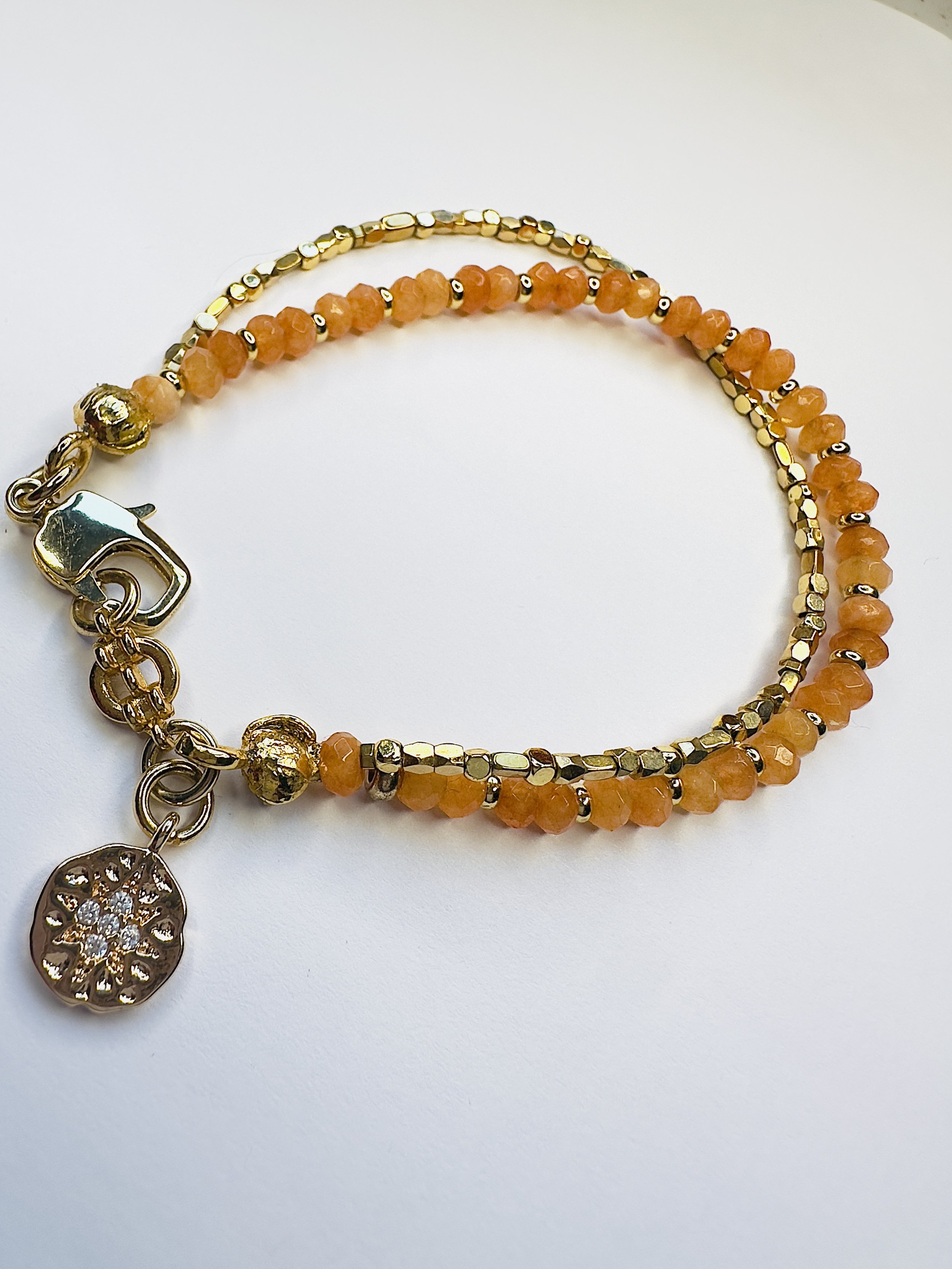 Close-up of polished orange calcite beads on the Ariadne Bracelet, highlighting their warm, sunny hues and smooth texture for a bold and vibrant look