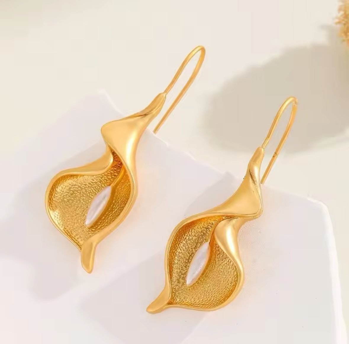 Eterna Earrings inspired by the calla lily, featuring a sculptural gold-plated brass design and a glass pearl by ÎLE KEKERE