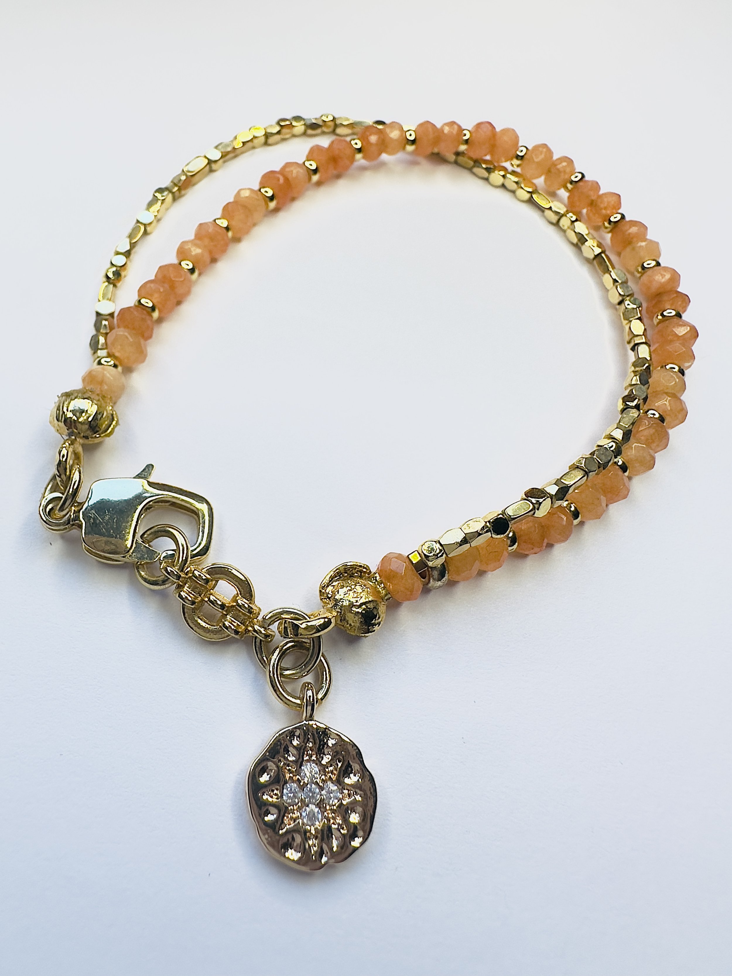 Ariadne Orange Calcite Bracelet photographed against a natural background, representing its connection to Oshun’s warmth, creativity, and abundance energy.