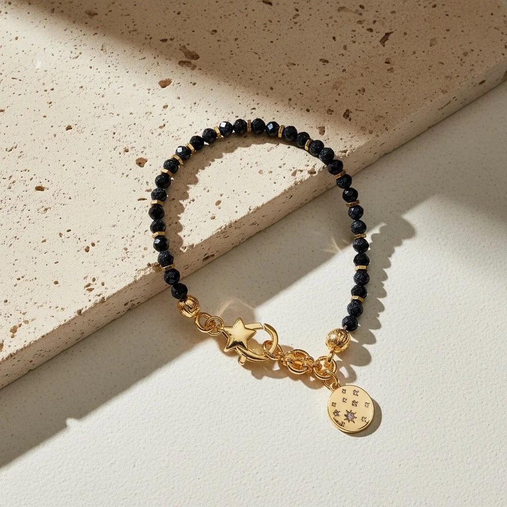 Celeste black spinel bracelet showing gold celestial charm with cubic zirconia