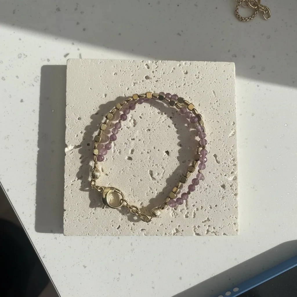Lepidolite beaded bracelet with gold accents on neutral background