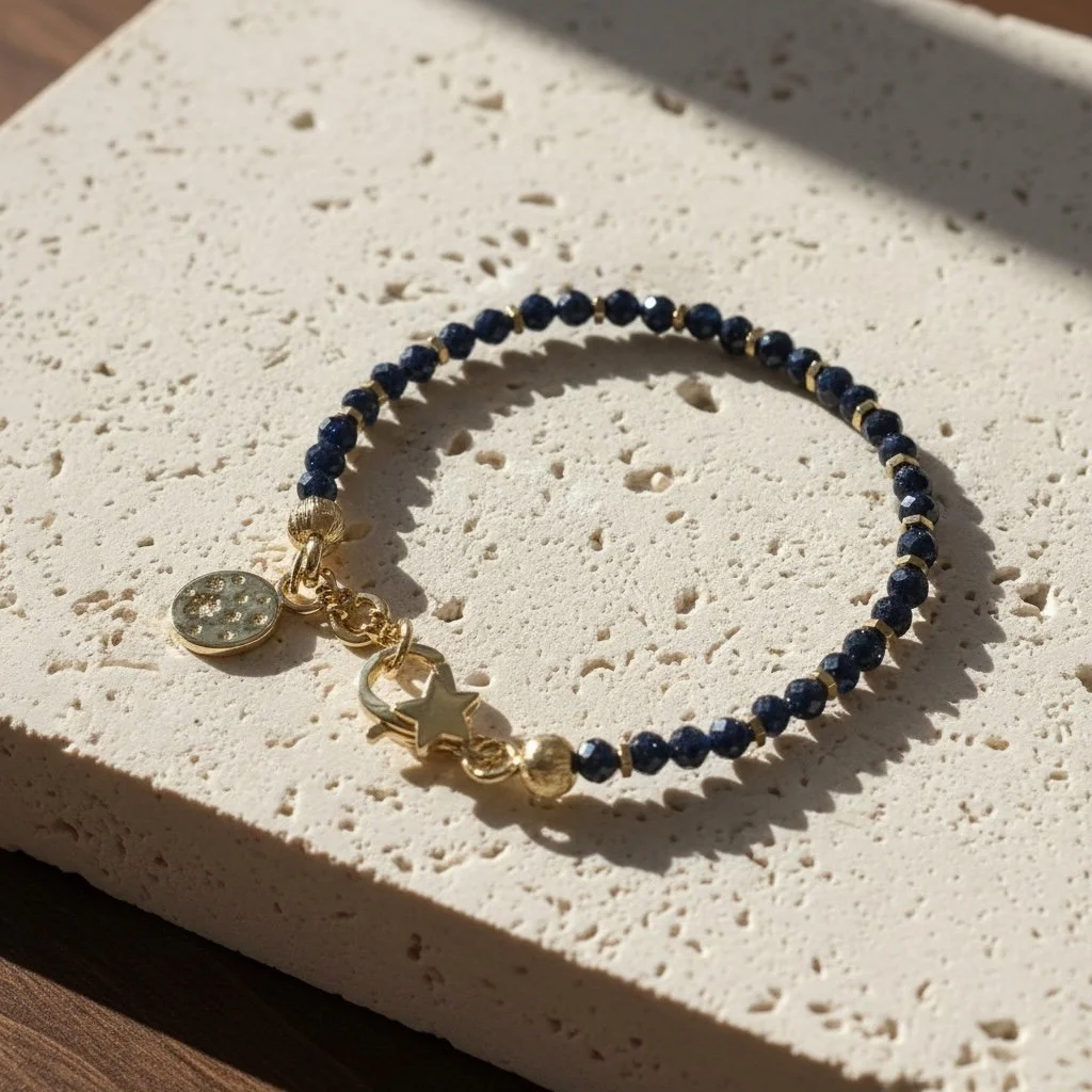 Faceted blue sandstone bracelet with gold-toned spacers and star clasp on light background