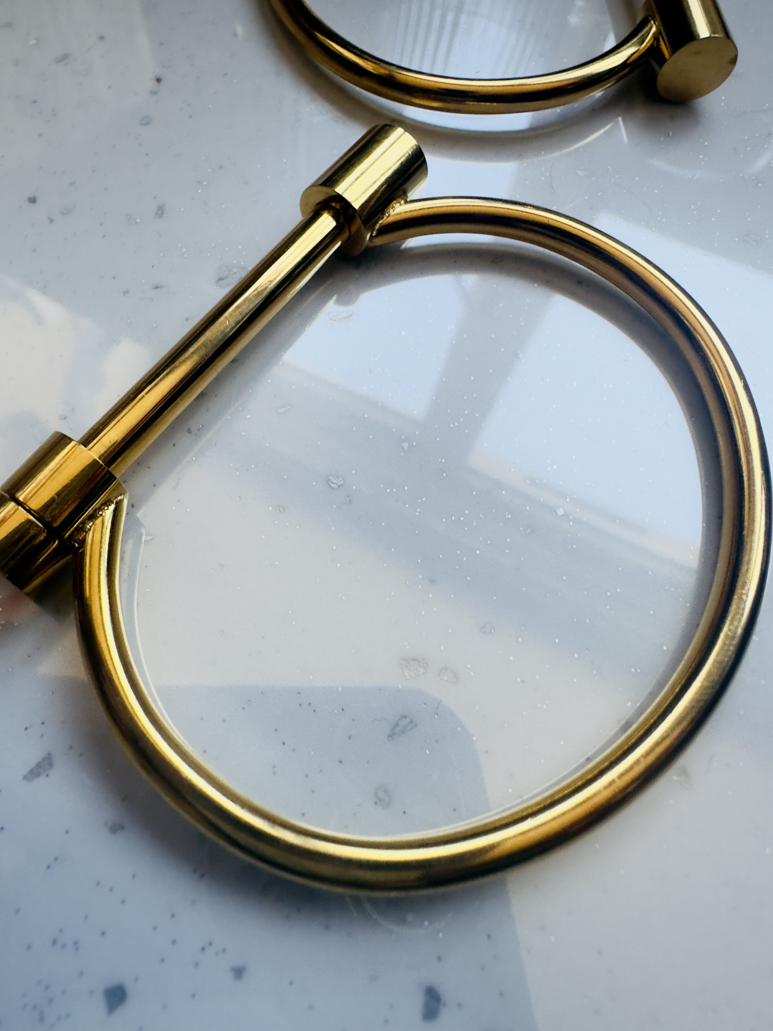 Close-up of Athena Bangle beside open book and candle, evoking sacred space and mindful ritual