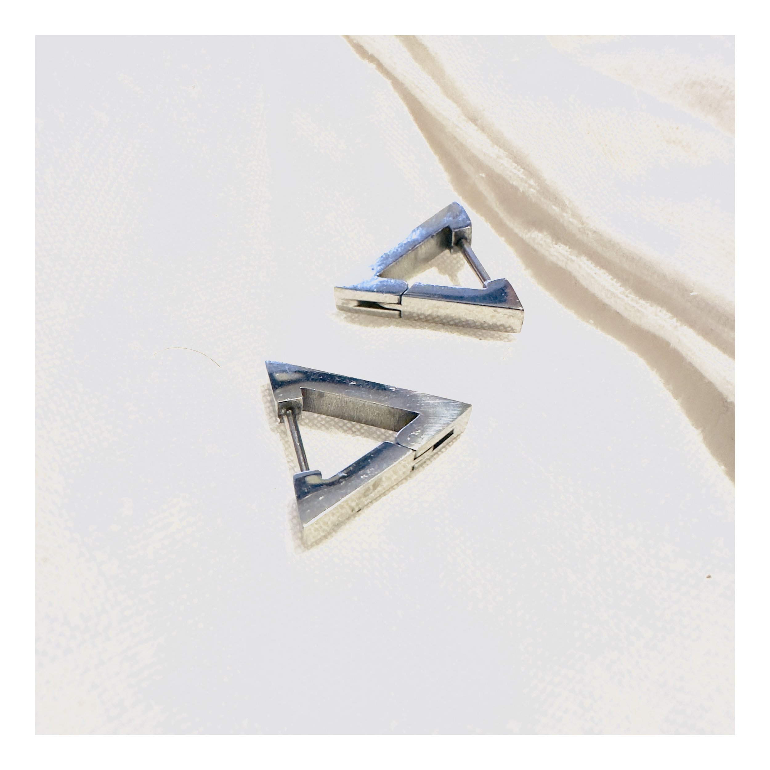 An illustrative shot of Silver Toned Giza Huggies lounging on a serene marble surface, celebrating sustainable luxury in its most stylish, down-to-earth form.