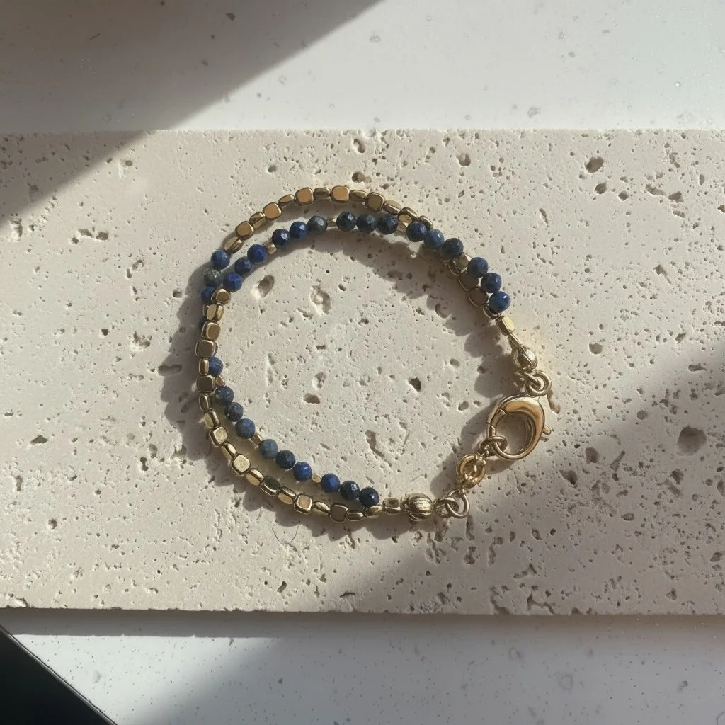 Lapis lazuli beaded bracelet with gold accents on neutral stone