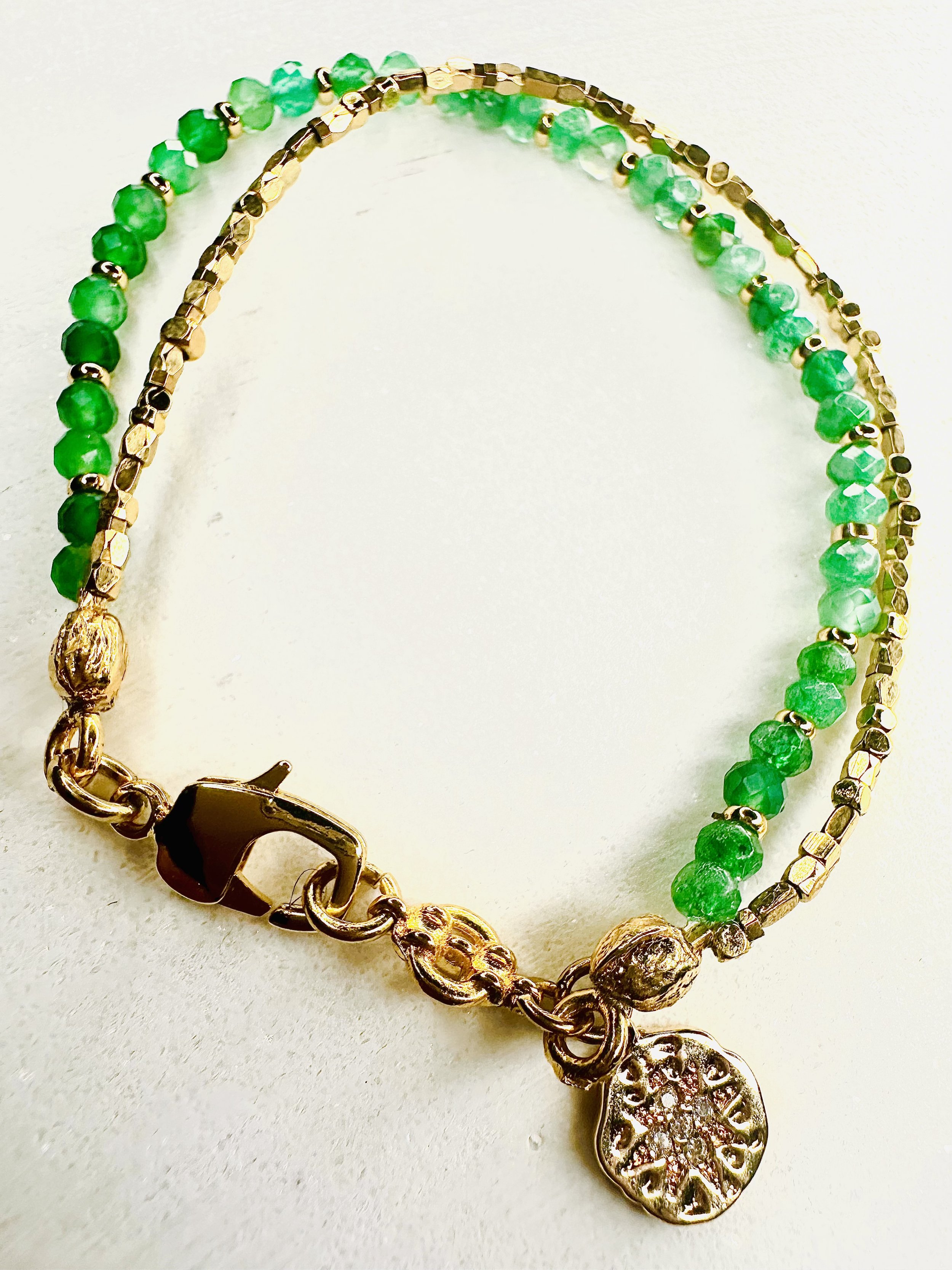 Female model wearing the Ariadne Green Fluorite Bracelet, surrounded by lush greenery, symbolizing growth and renewal