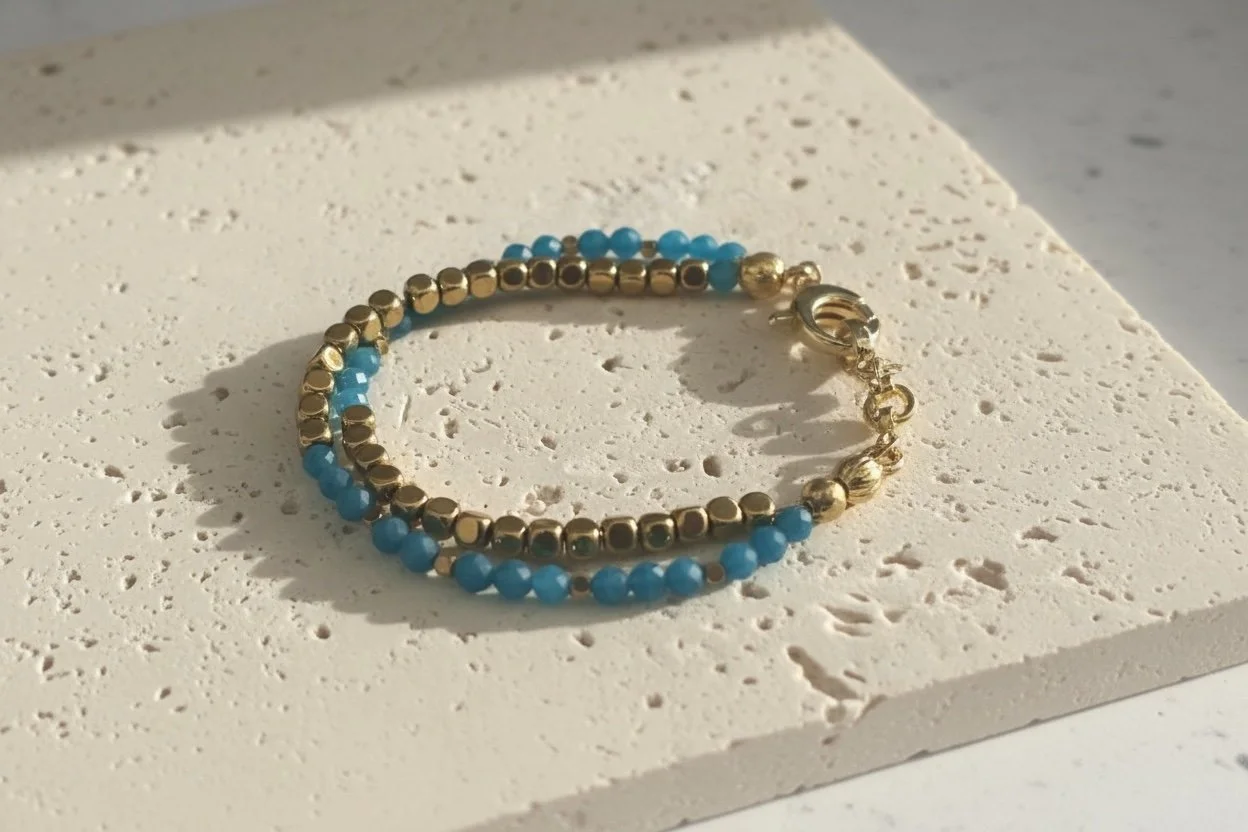 Blue chalcedony beaded bracelet with gold accents on neutral stone