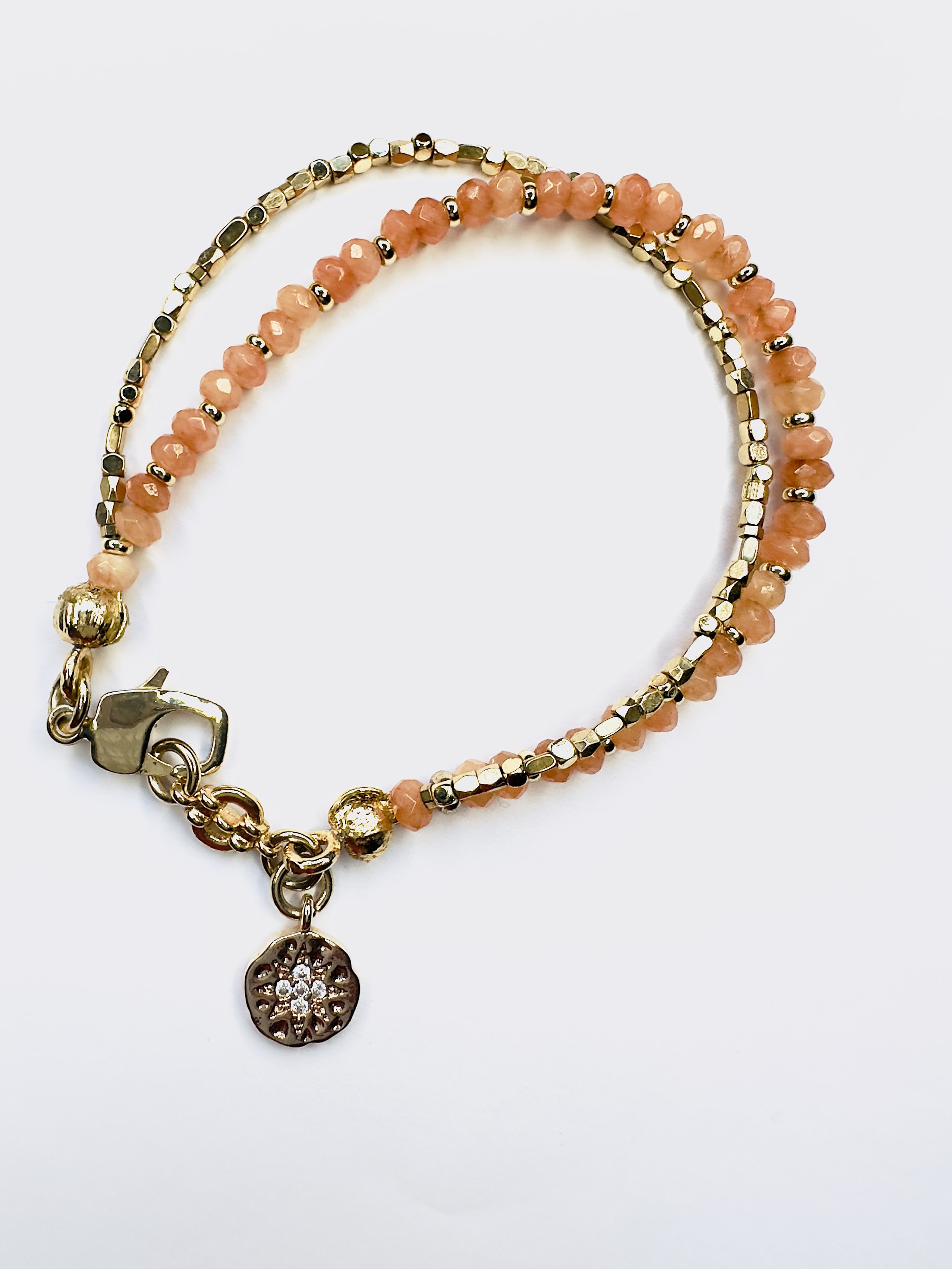 Lifestyle image of the Ariadne Orange Calcite Bracelet, worn in a playful, relaxed setting, radiating confidence and joy through its vibrant gemstone design
