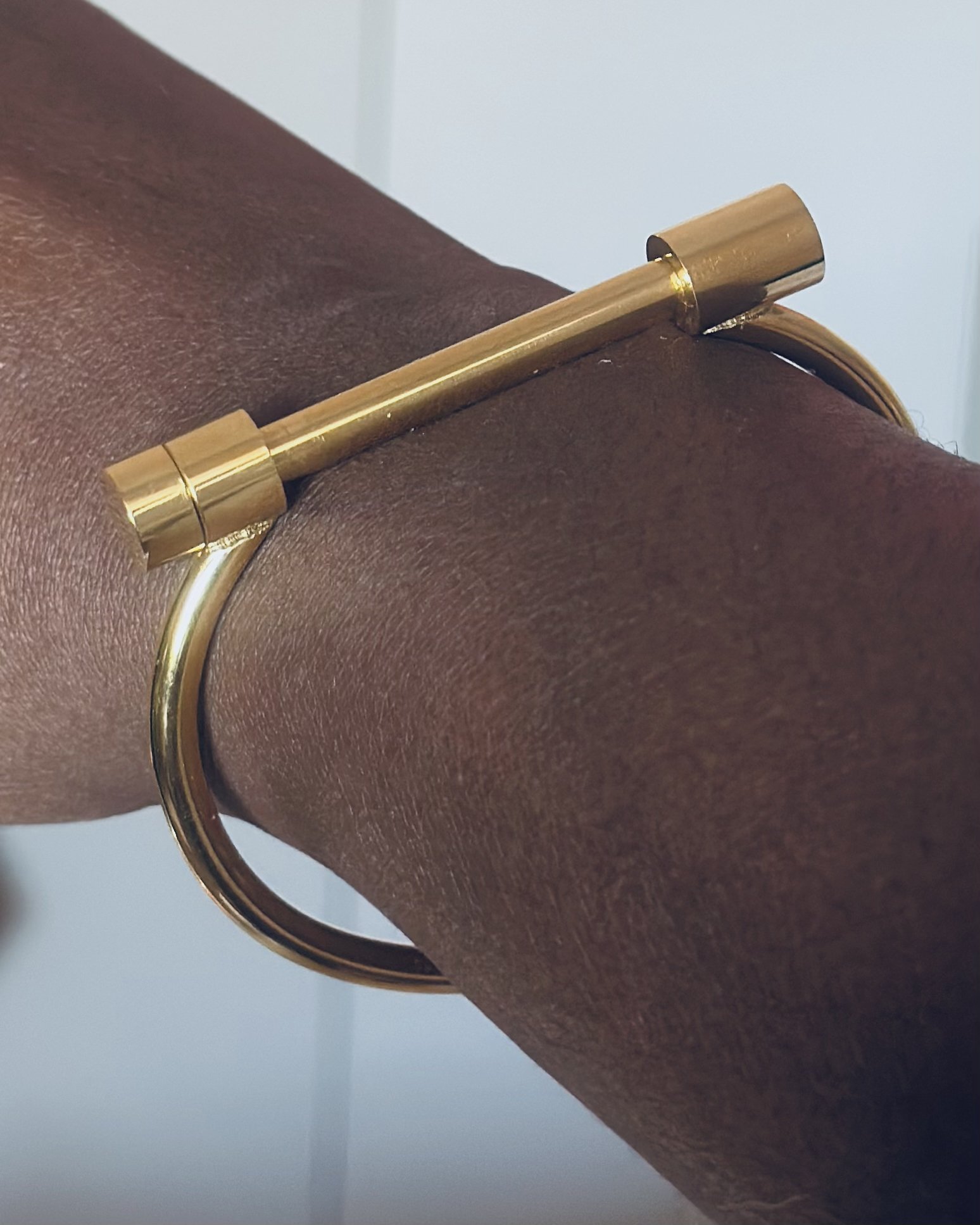 Athena gold bangle with T-bar clasp symbolising clarity and power