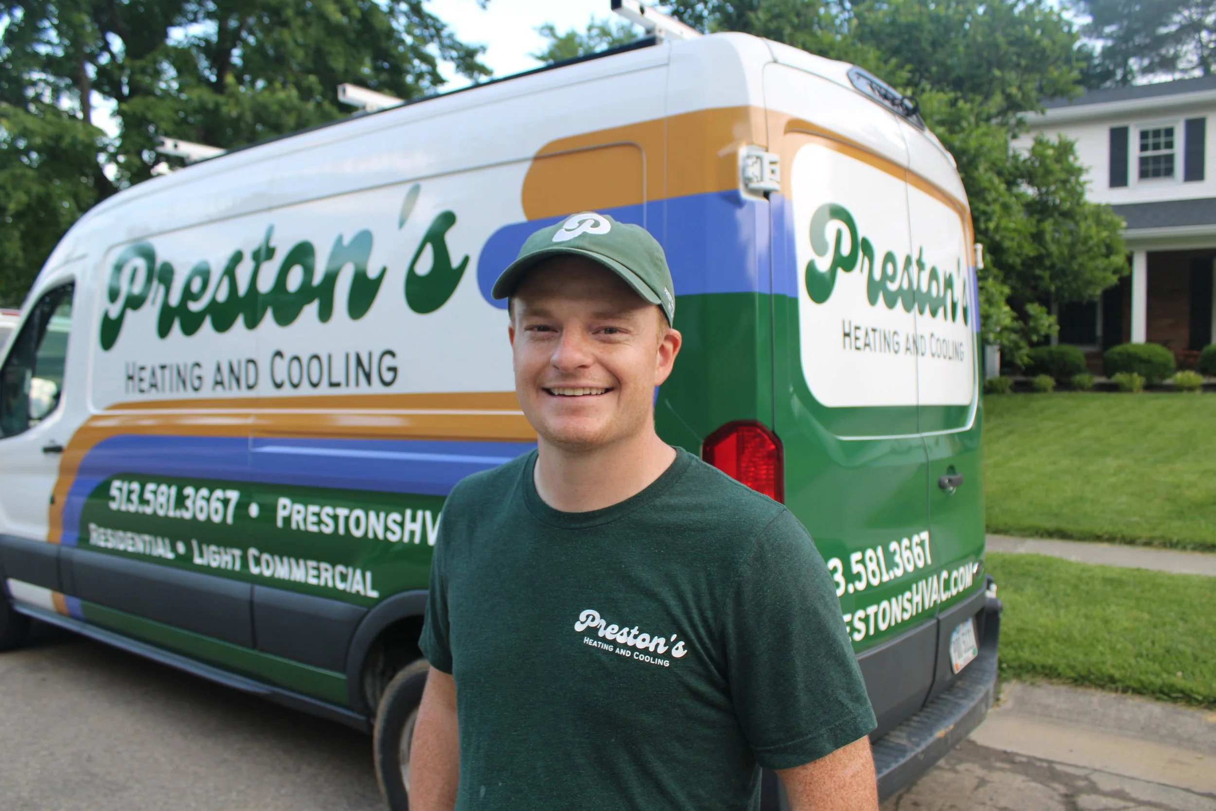Smiling Man in Green HVAC shirt and Green hat in front of an HVAC service van in Cincinnati Ohio