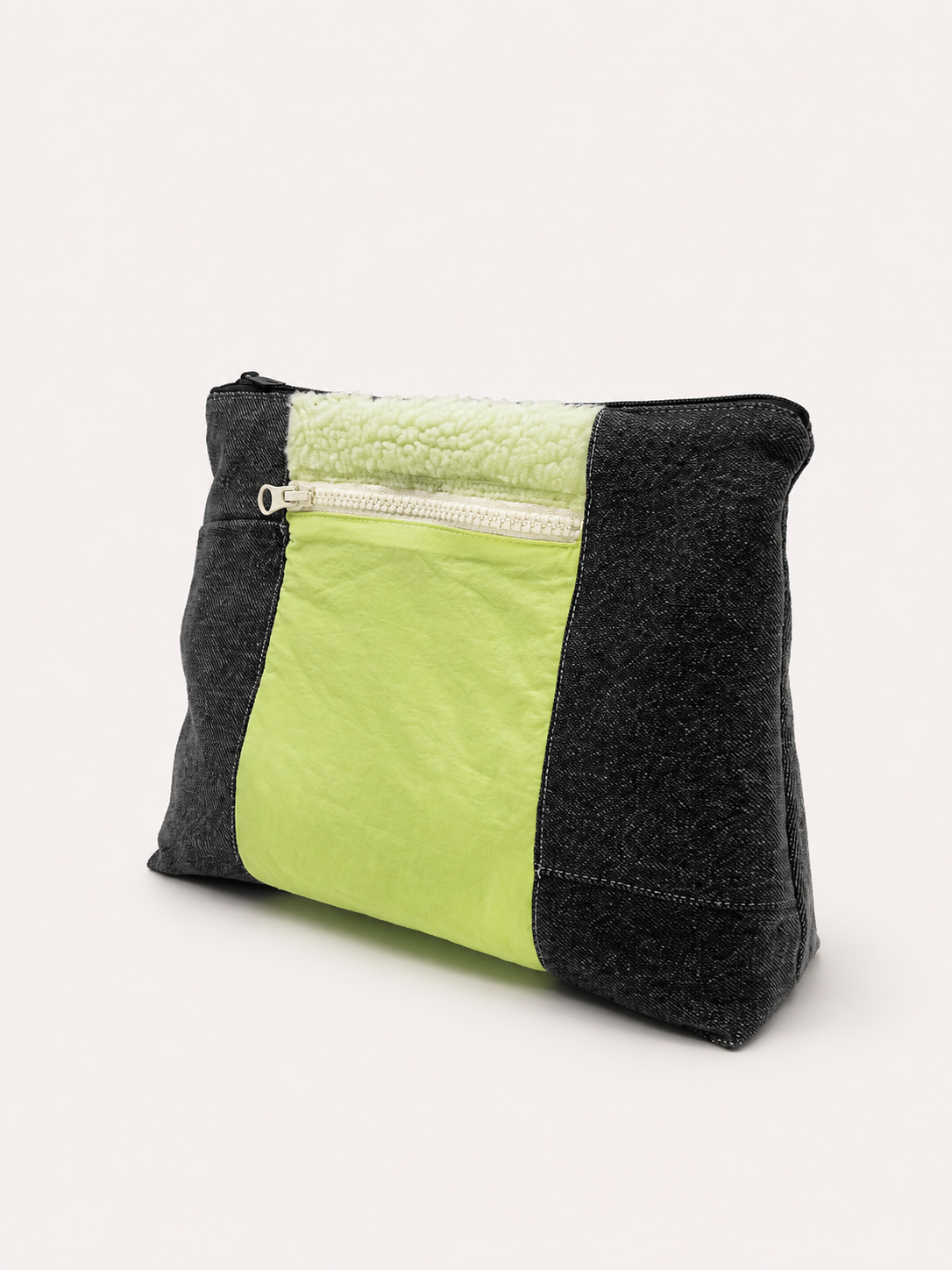 Sac fourre-tout rectangulaire en tissu noir et vert fluo, avec poche zippée sur le devant, posé sur fond blanc.