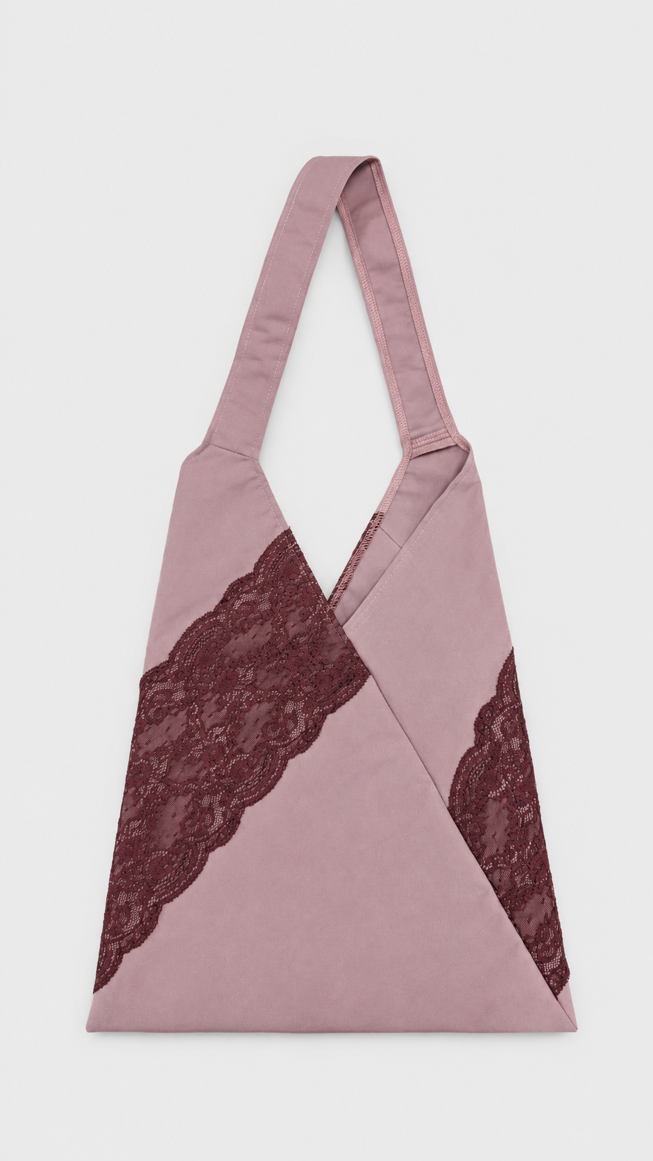 Sac en tissu rose avec des détails en dentelle rouge foncé.