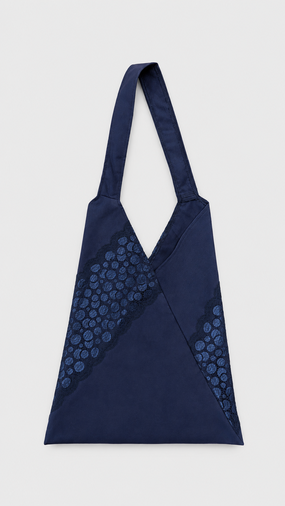 Sac en tissu bleu avec des motifs en dentelle.