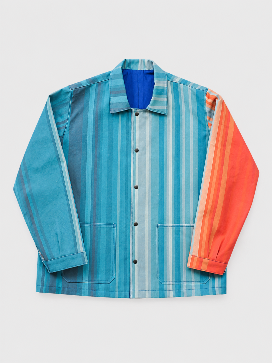 Veste en tissu à rayures colorées, avec différentes nuances de bleu et une manche orange.