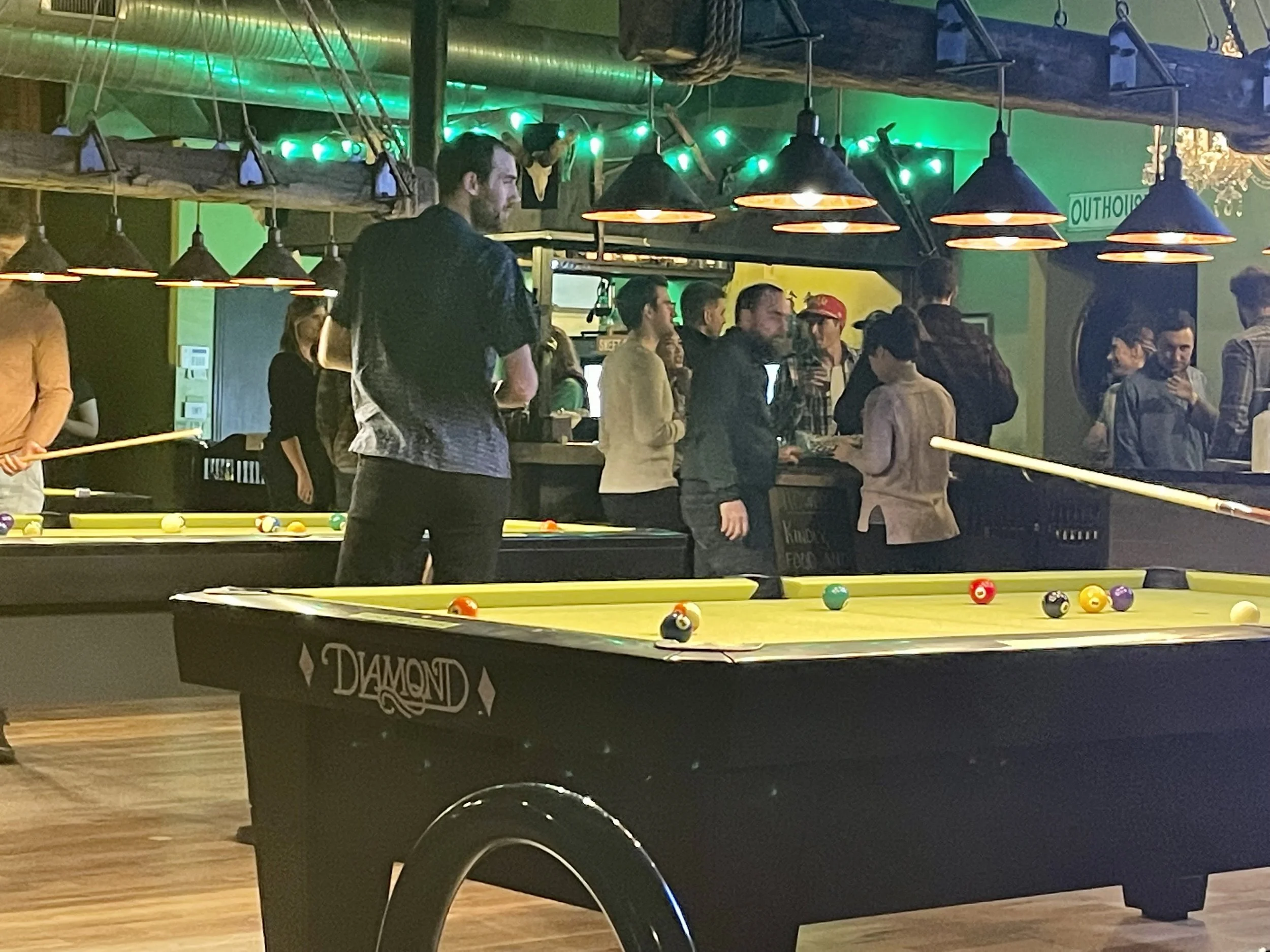 Guests enjoying challenge games on 9 ft. Diamond tables at Chartreuse Saloon in Kansas City.