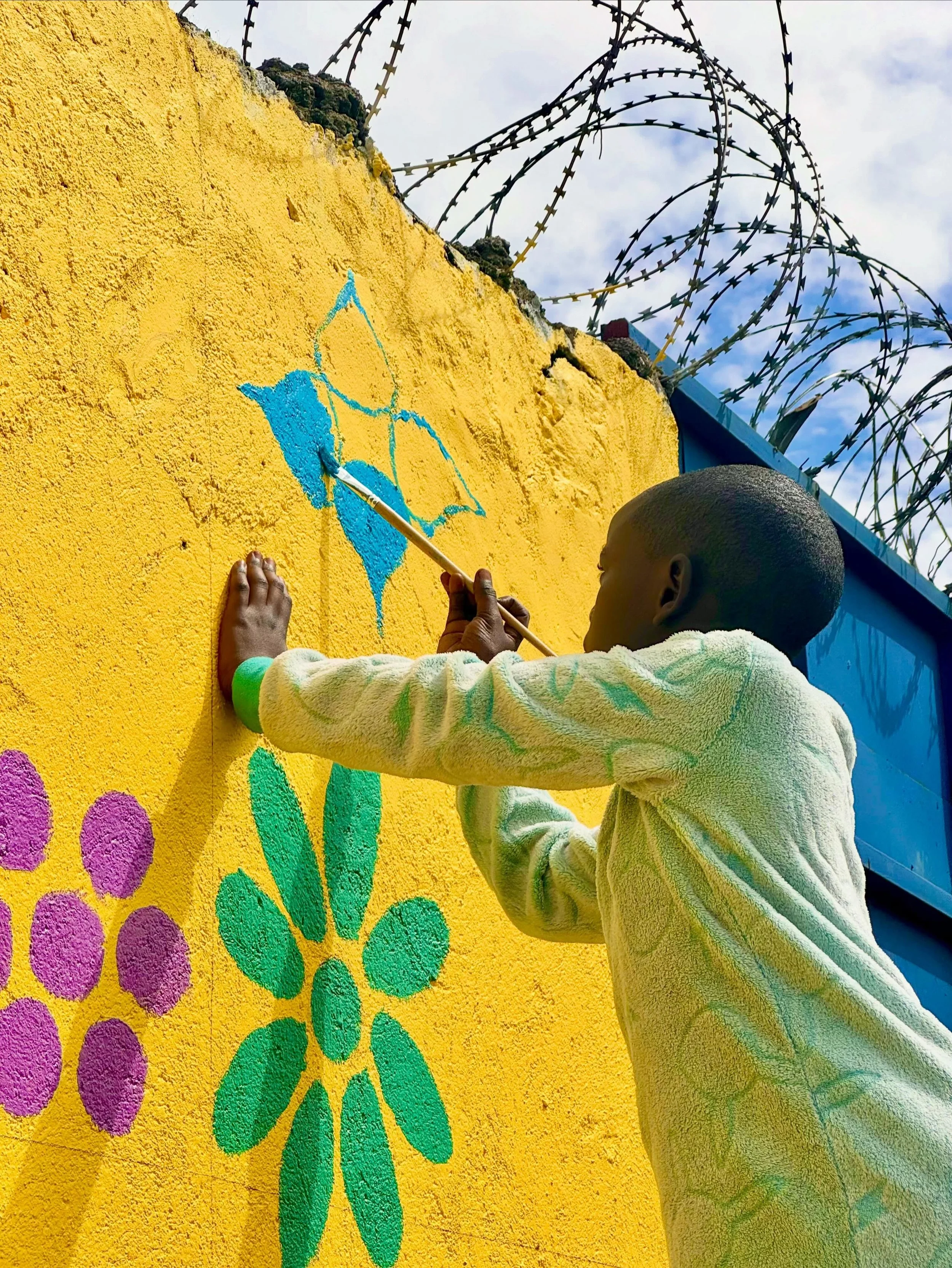 196 girls worked on the 11 meter mural, with young women mentors facilitating the process. Painting was as chaotic, exciting, and full of joy as we anticipated it would be 💕

Girls were so proud to be seen working on the wall, telling their friends 