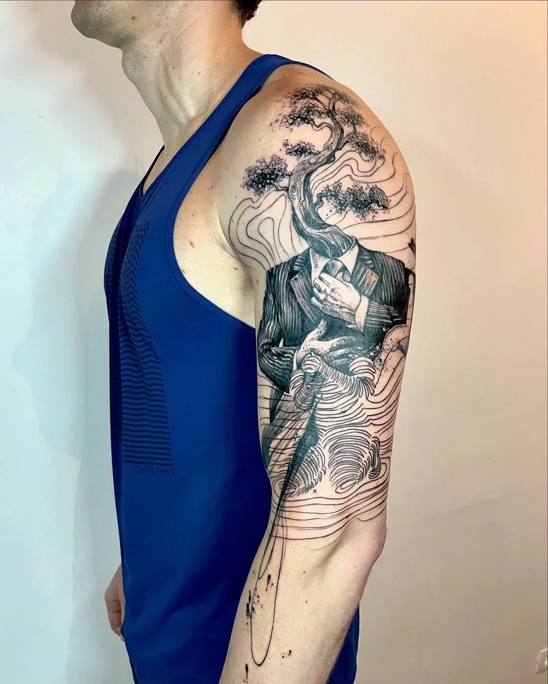 Tattoo of a man in a suit with a tree growing from his head