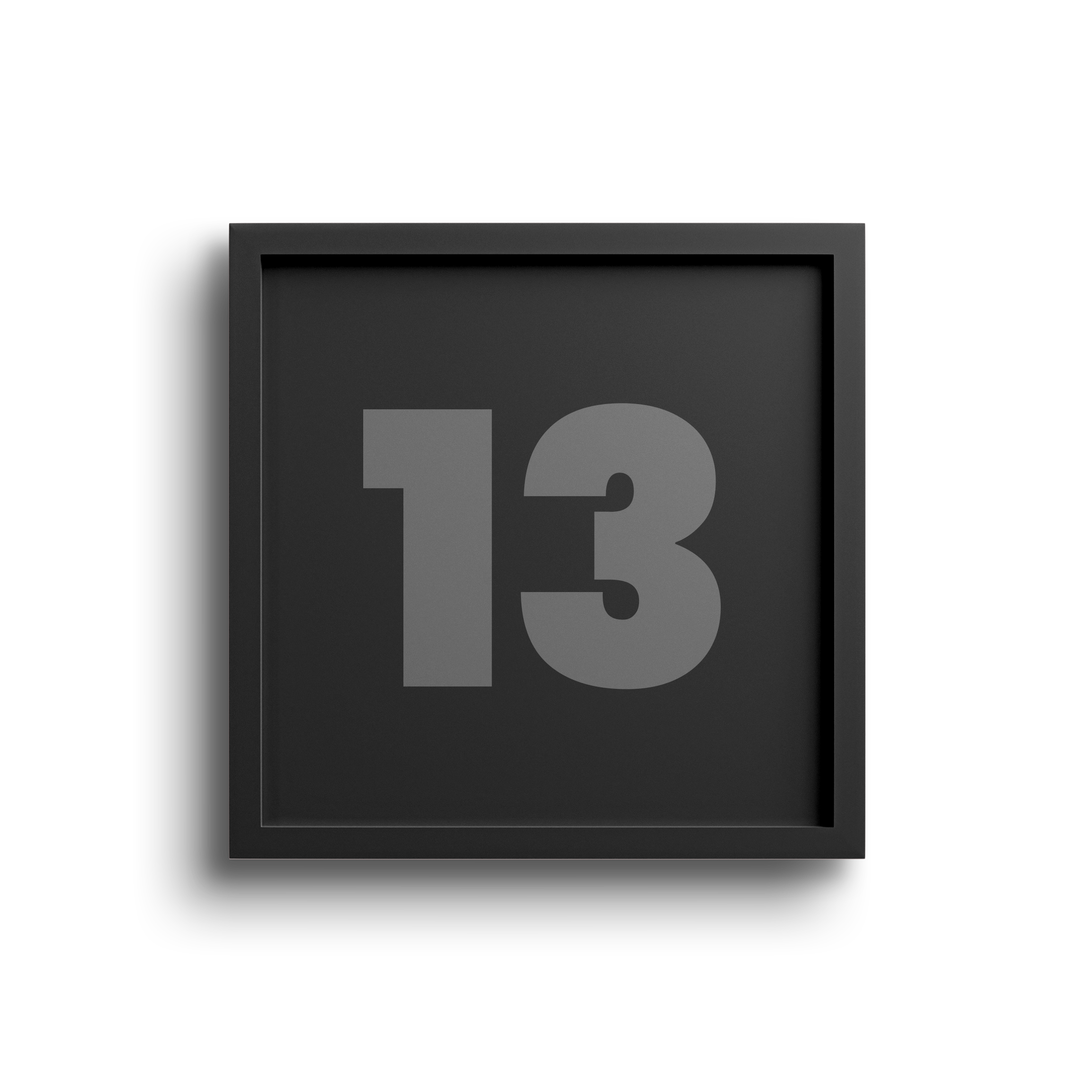 A black clock with grey numbers displaying the number 13, positioned against a black and beige background.