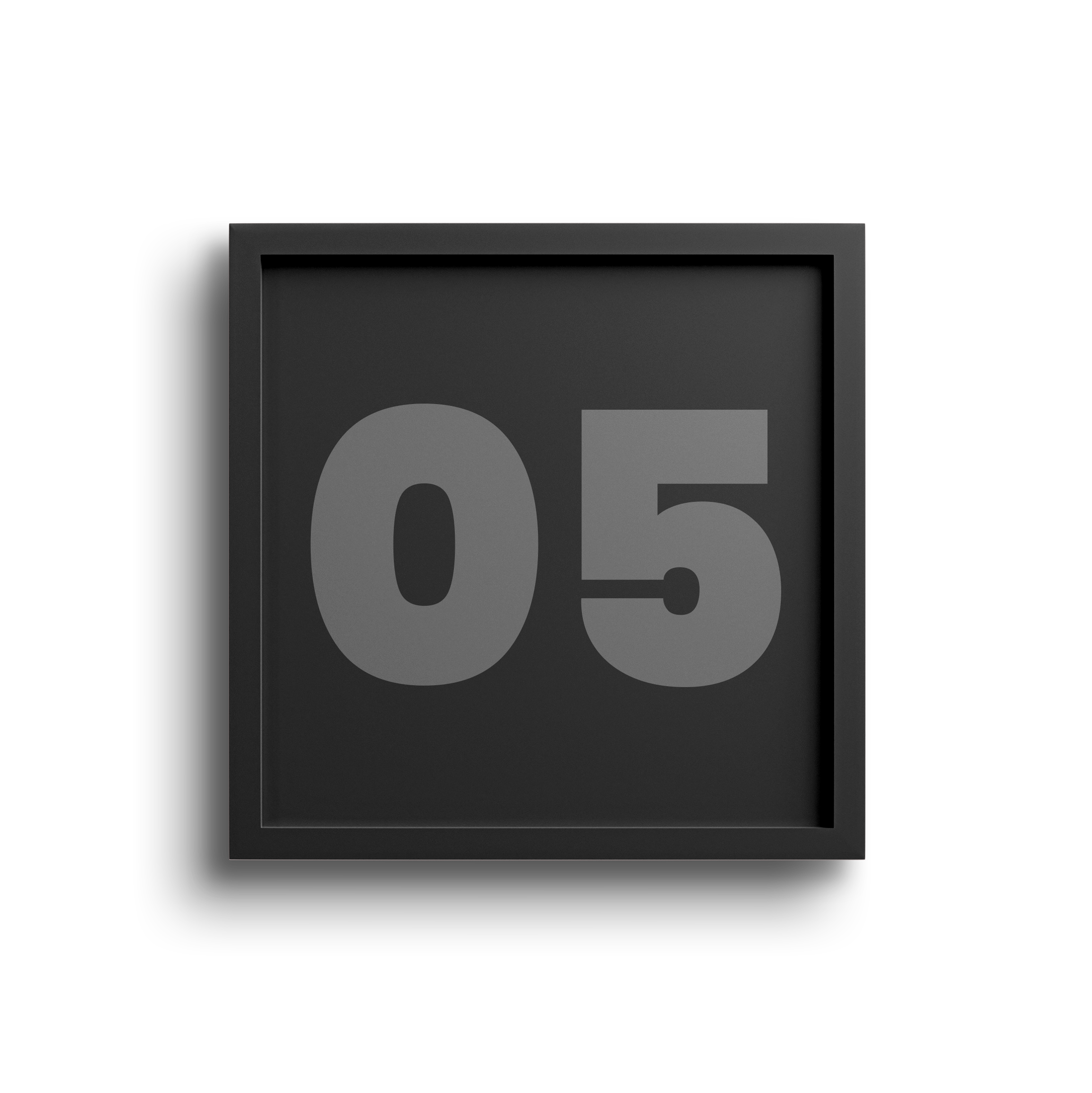 Close-up of a black digital flip clock displaying the time 05, with a blurred background.