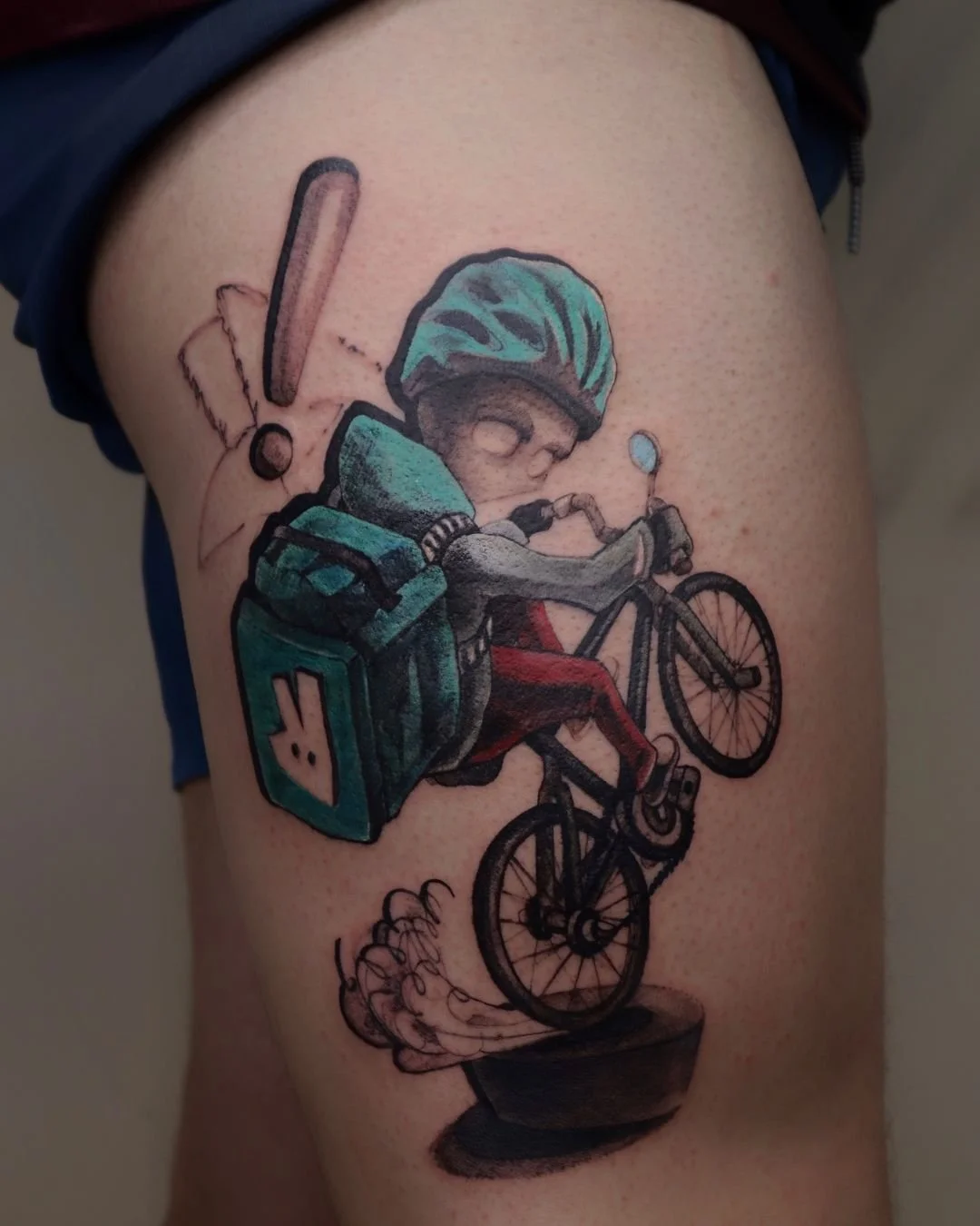 Tattoo of a cartoon cyclist on a leg