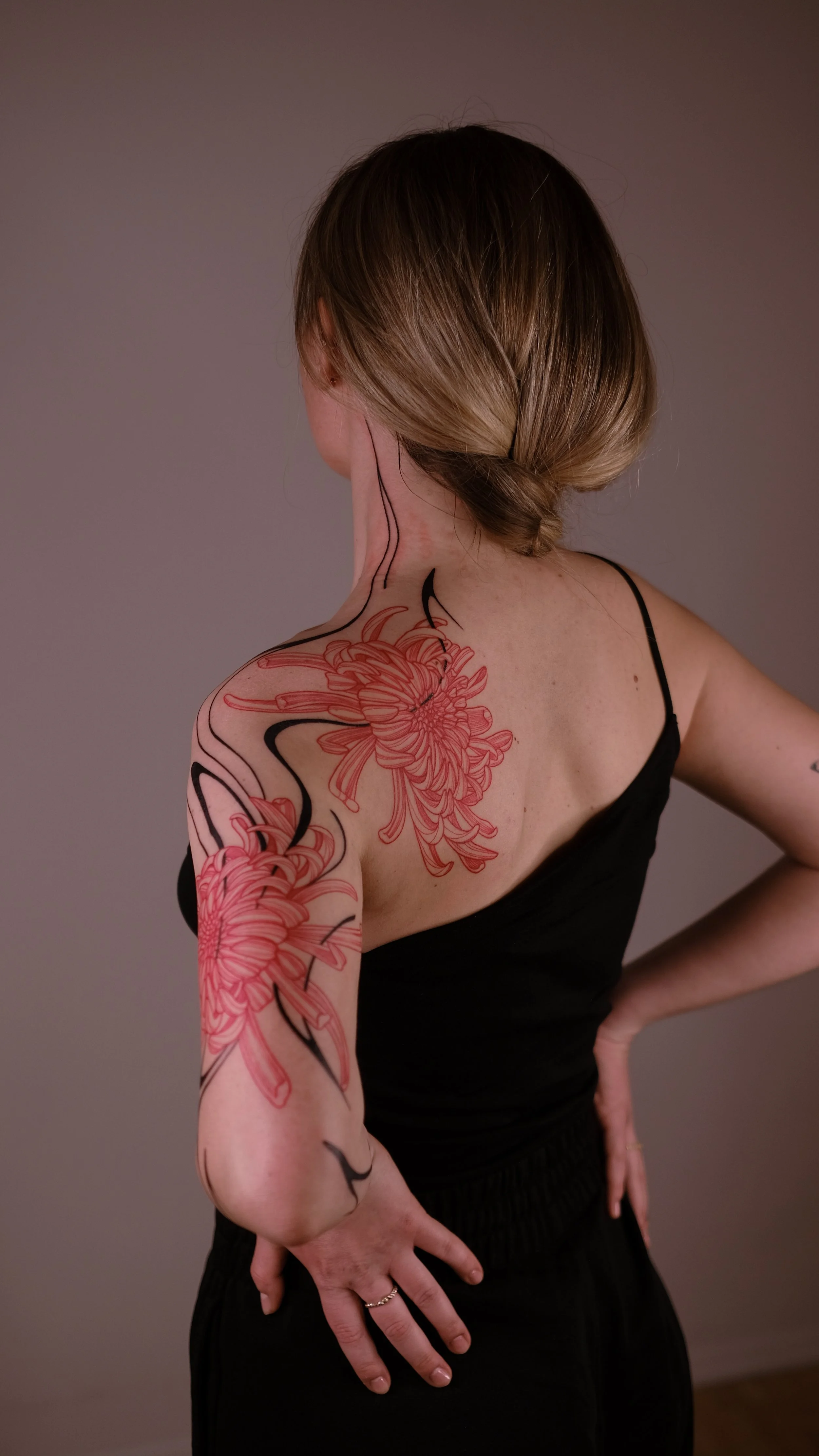 Woman with floral tattoo on back and arm