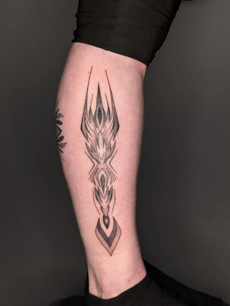Black geometric tattoo on person's calf extending from below the knee to above the ankle.