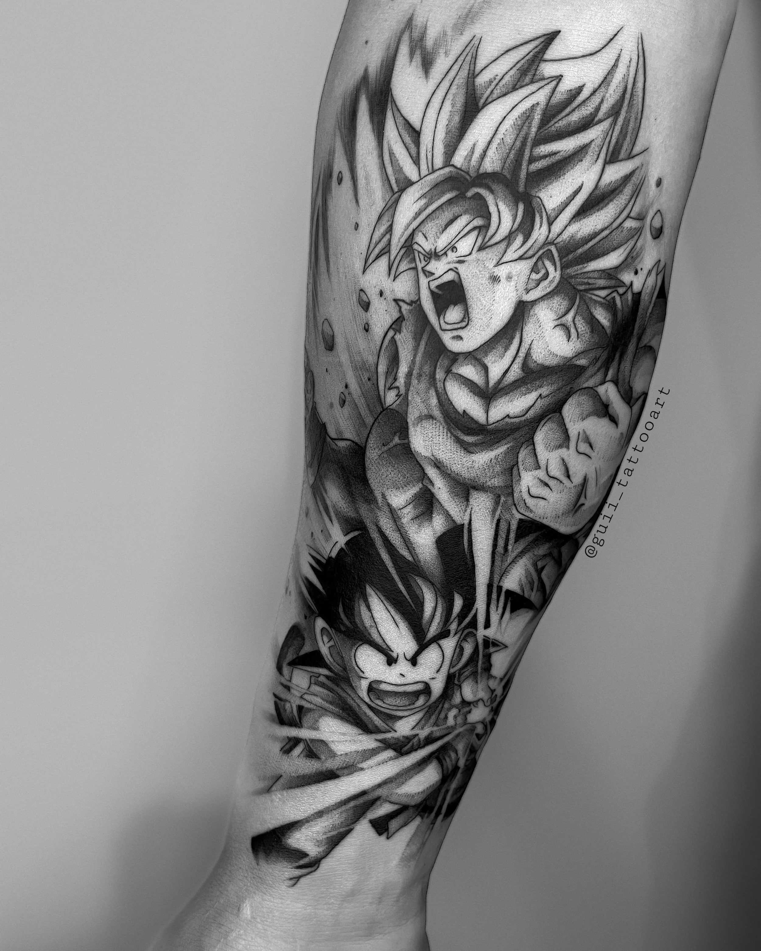 Black and white tattoo featuring two animated characters in dynamic poses, one with spiky hair and both showing intense expressions.