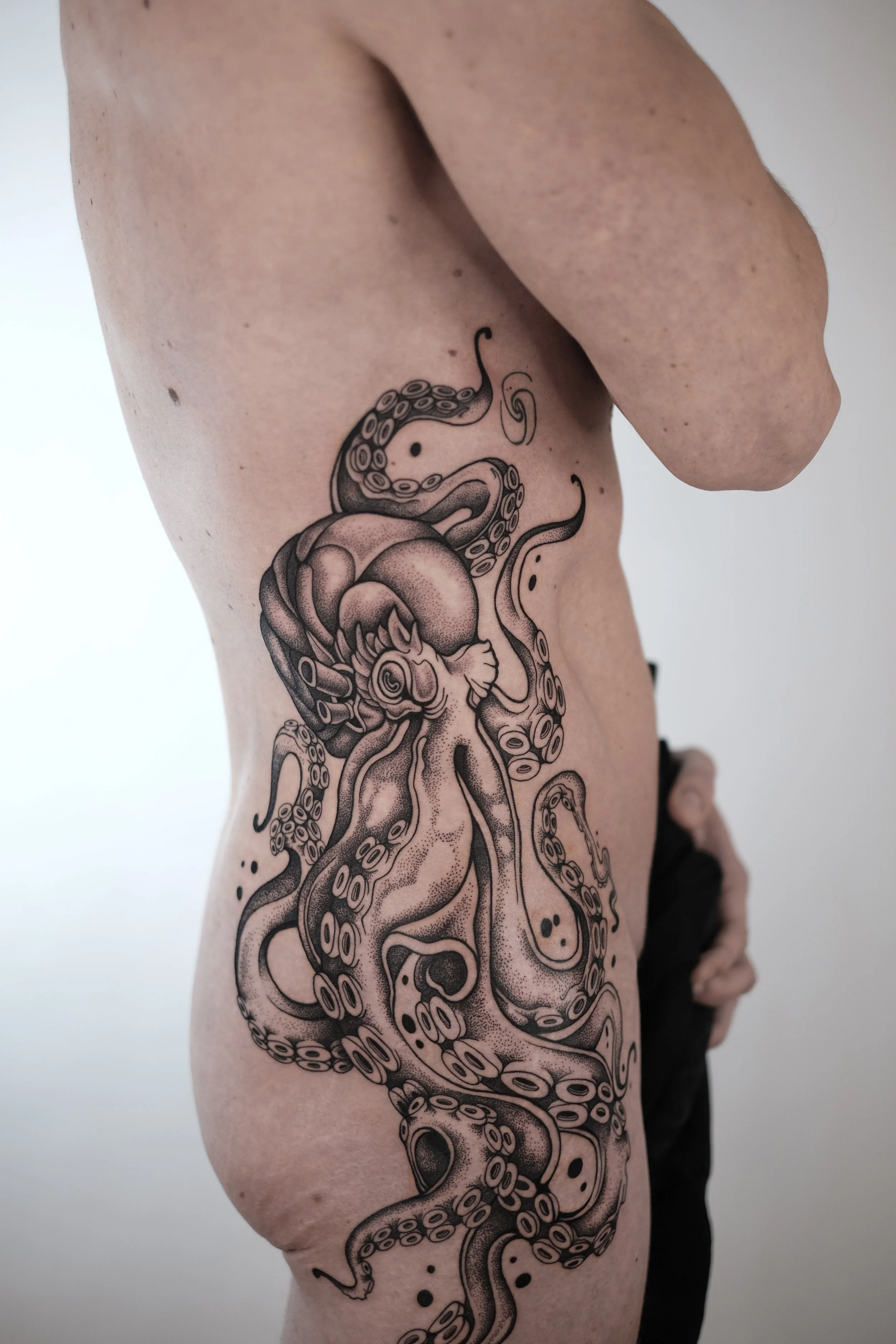 Tattoo of an octopus on a person's ribcage.