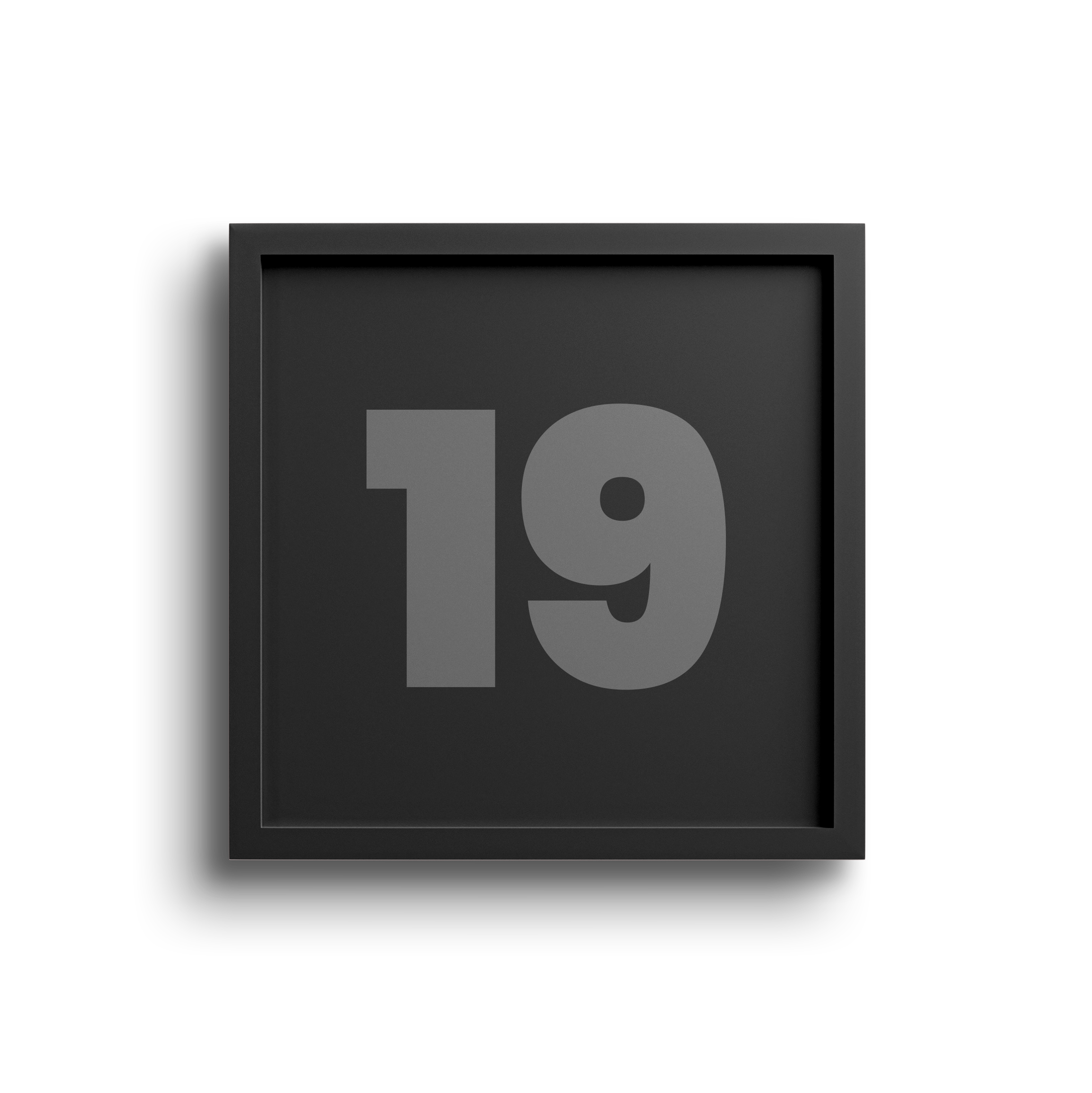 Digital black calendar displaying the number 19 in gray with a black border and gray background, partially over a light pink surface.