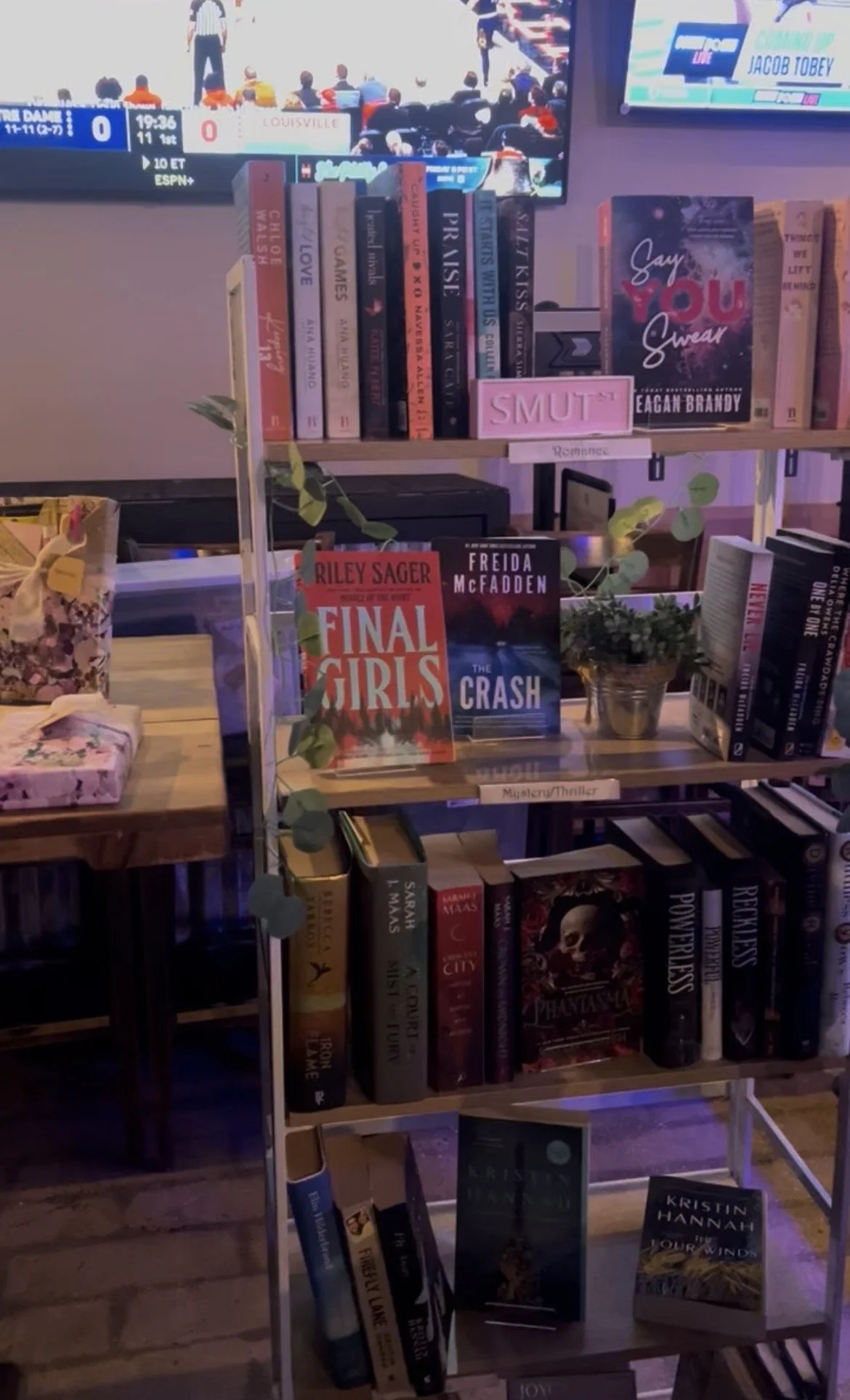 Photo of books on a bookshelf at a bar. Photo is taken at DAS Beer Garden during the Beer + Book Fair with Wandering Words Bookstore.
