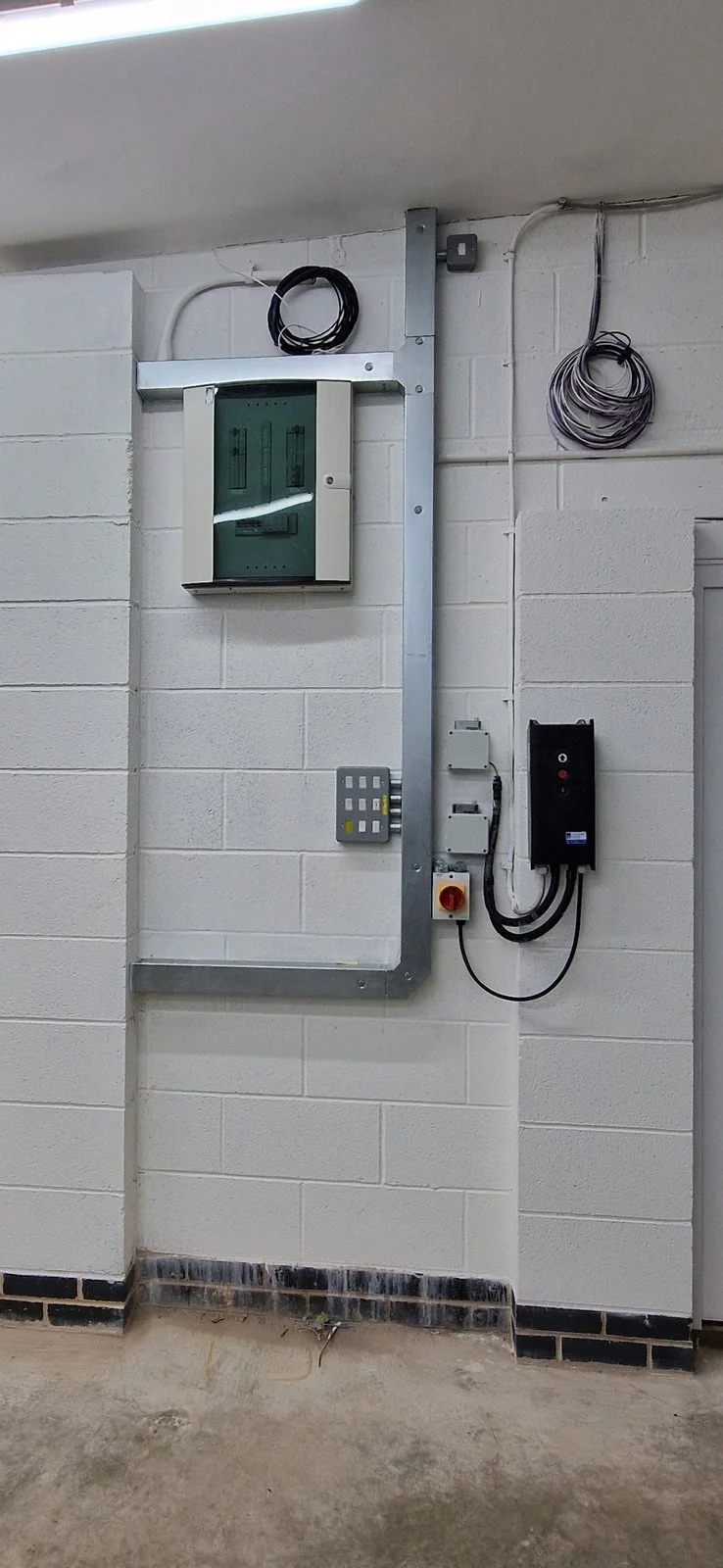 Galvanised steel trunking to a new distribution board with a rotary isolator in a commercial unit