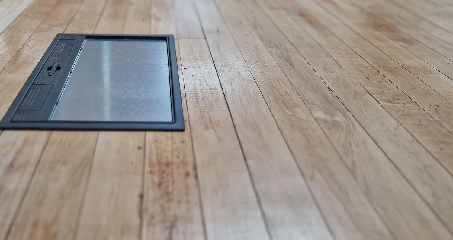 Flush floor box set into a timber floor to give power where it is needed in a commercial space