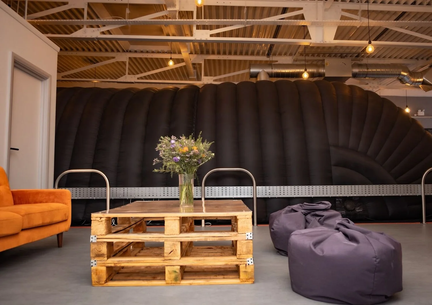 Finished Hot Pod Yoga studio lounge with pendant lighting, exposed ductwork and cable tray in a converted industrial unit, Leicester