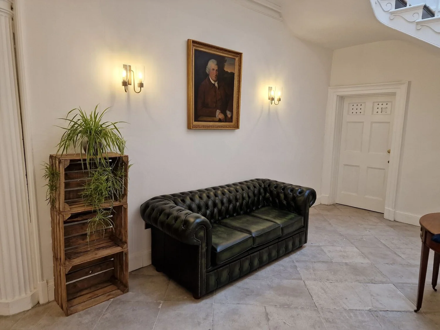 Period reception room with brass wall lights either side of a portrait, Leicester city centre