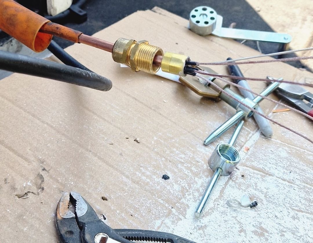 Mineral-insulated (pyro) cable with its brass gland and sealing pot made off, with termination tools laid out on site