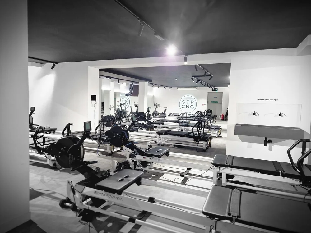 Pilates studio with LED track spotlights over rows of reformer beds, Leicester
