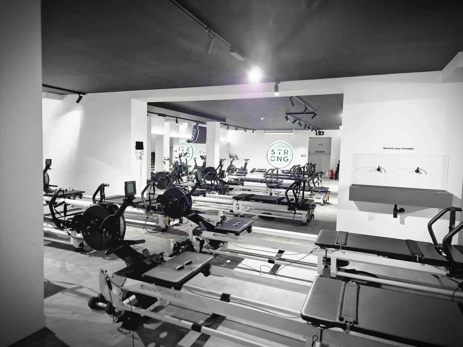 Pilates studio with LED track spotlights over rows of reformer beds, Leicester